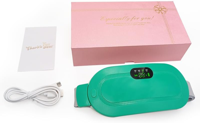 Ein grüner elektrischer Heizgürtel, ein weißes USB-Kabel, eine Grußkarte und eine rosa Geschenkbox auf einer weißen Oberfläche.