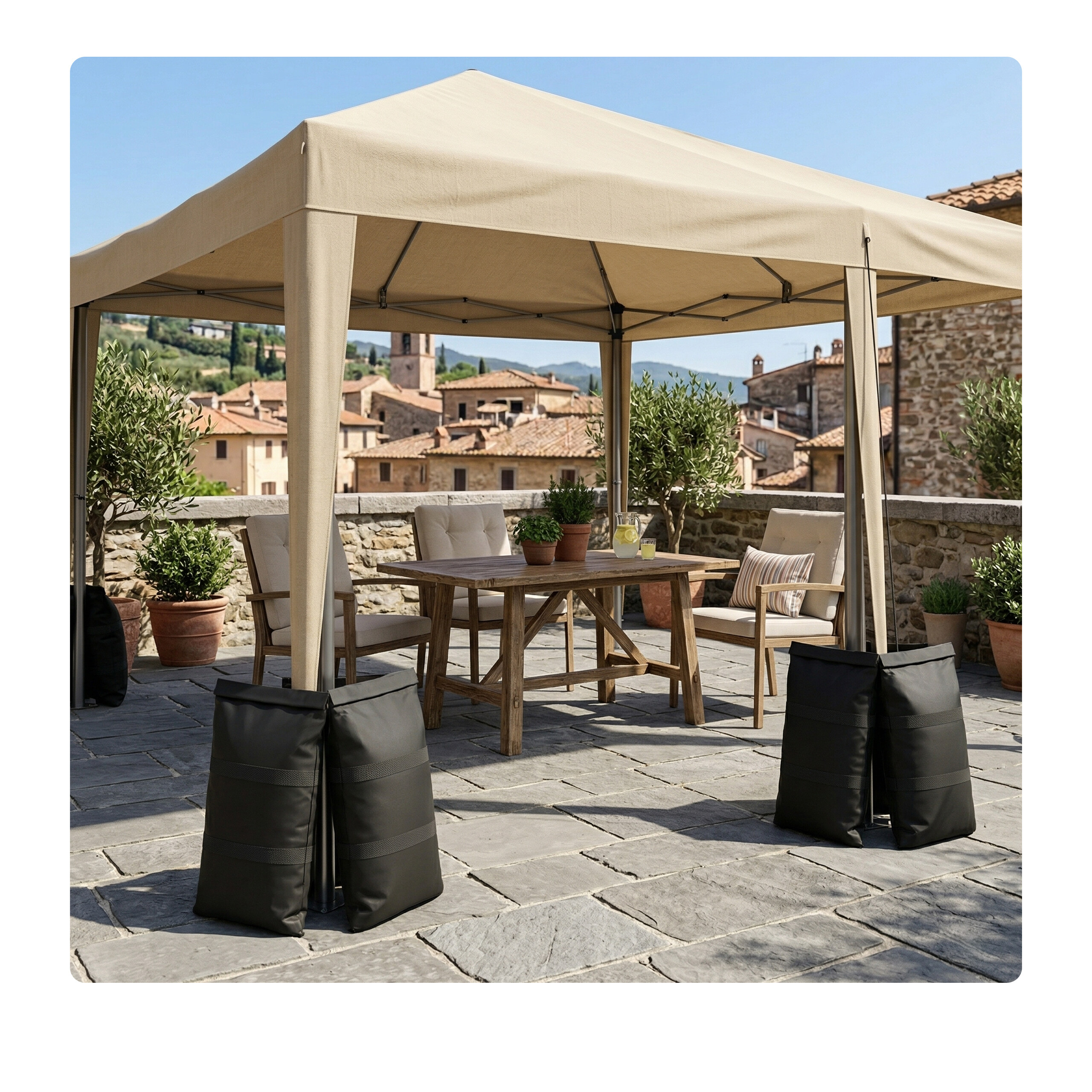 Ein beigefarbener Pavillon mit schweren schwarzen Taschen an den Beinen steht auf einer Steinterrasse mit Holztisch und Pflanzen.