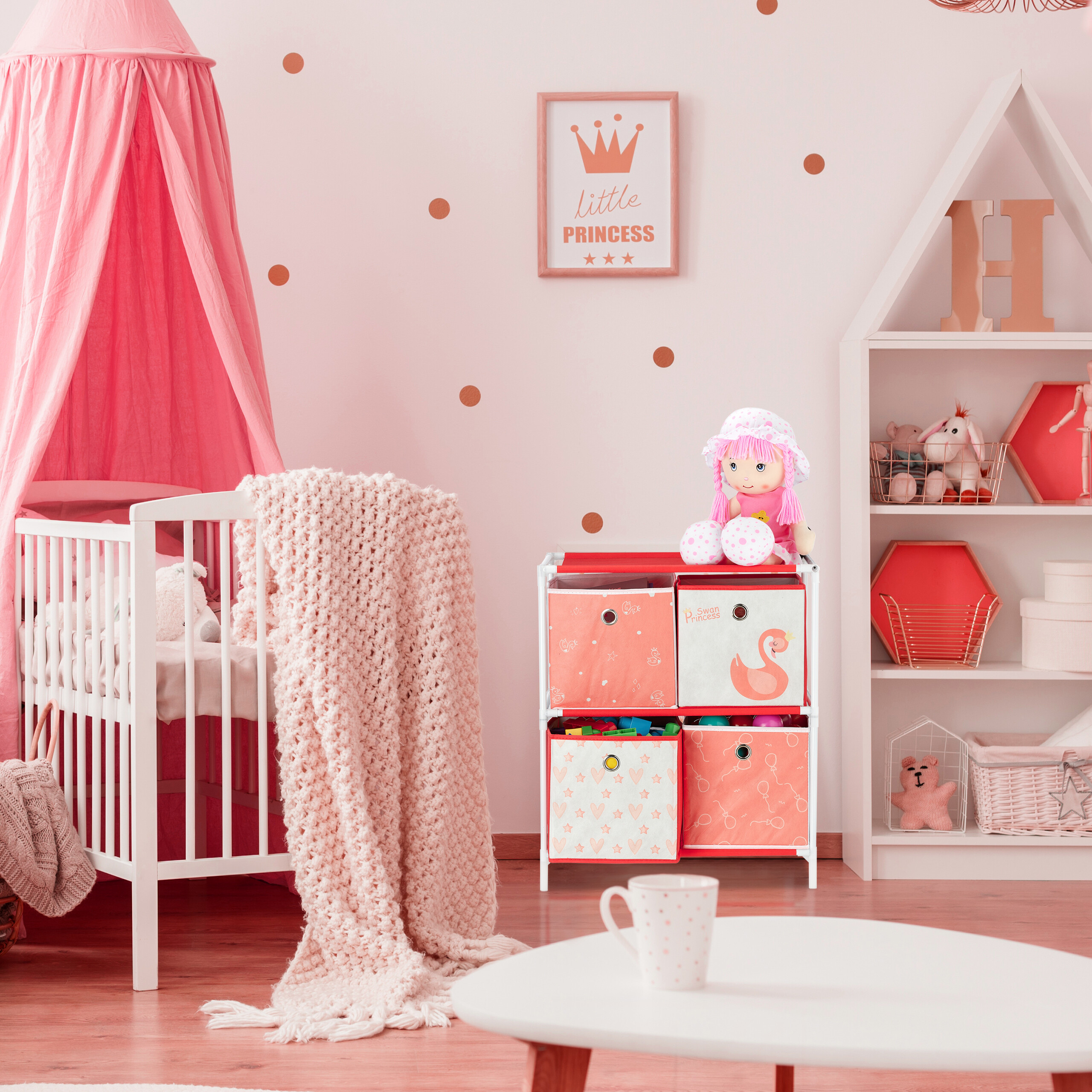 Ein rosafarbenes Kinderzimmer mit weißem Bett, Vorhang, Aufbewahrungsregal, Puppe, Wandbild und weißem Tisch.