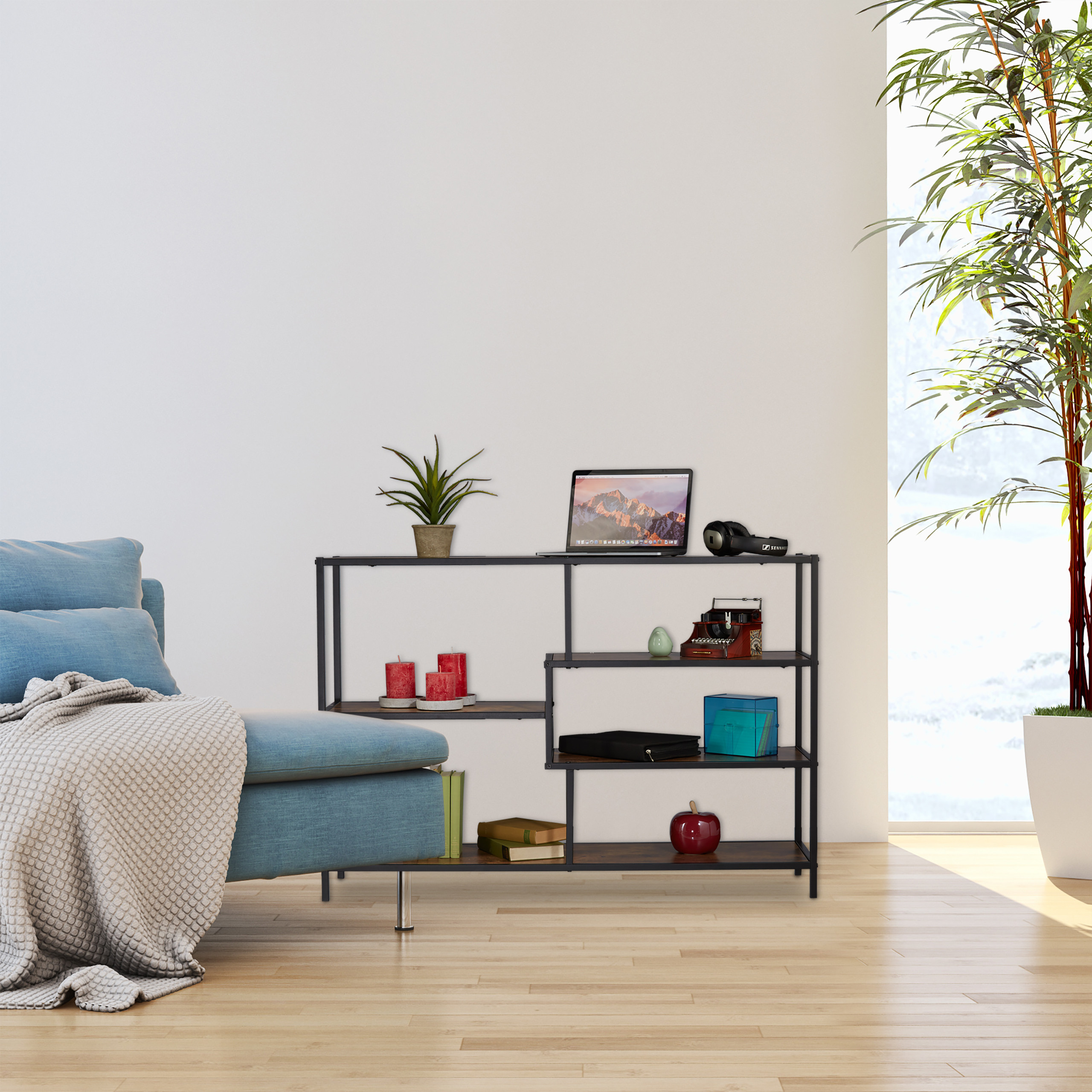 Ein Metallregal mit Laptop und Deko steht neben einem blauen Sofa und einer großen Pflanze.