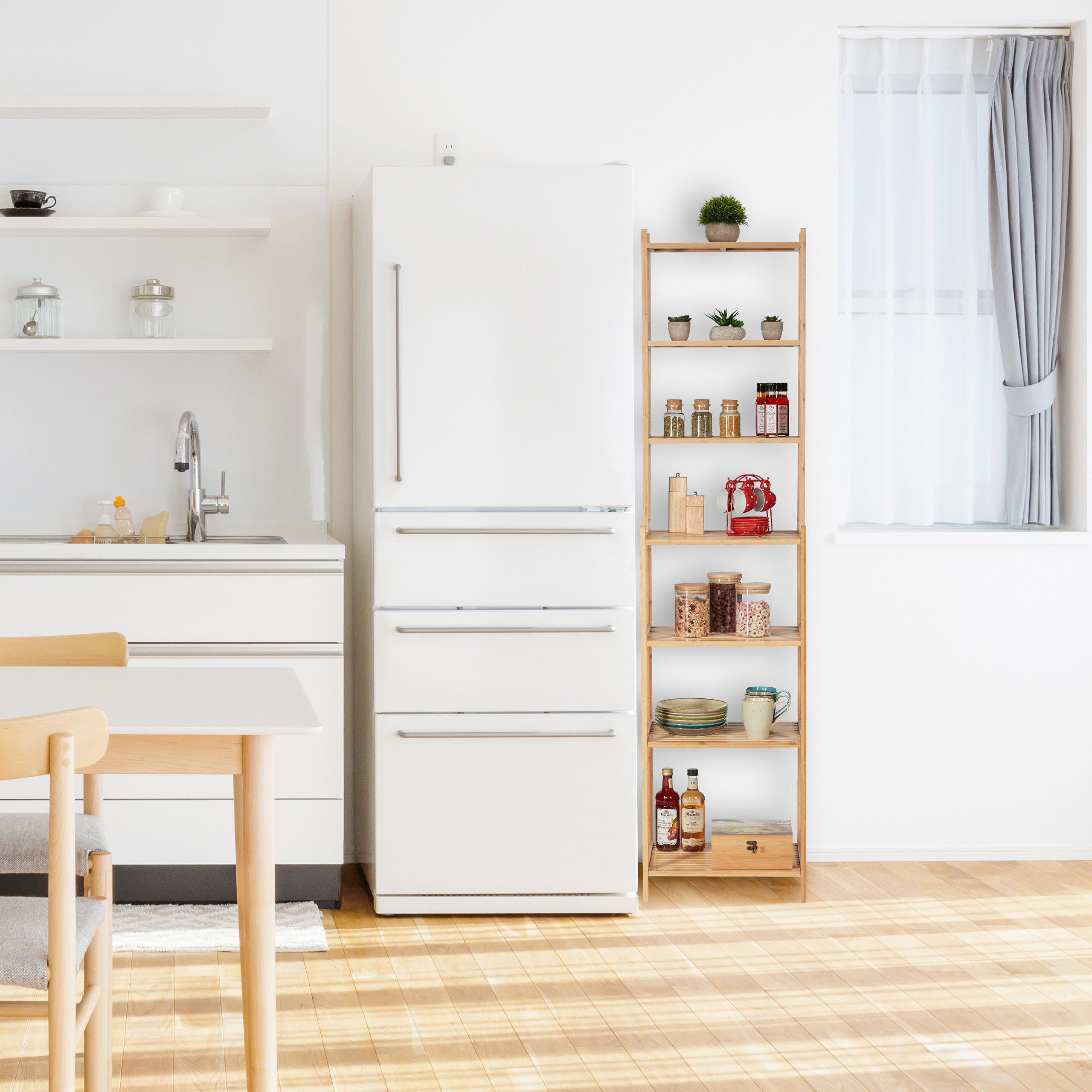Helle, saubere Küche mit weißem Kühlschrank, Holzregal und Esstisch auf hellen Holzböden.