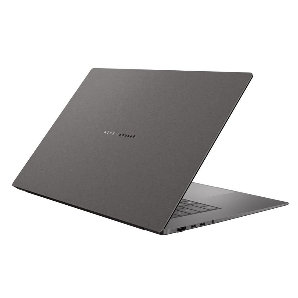 Szary laptop ASUS Zenbook jest otwarty na białej powierzchni, z widocznym logo i portami.