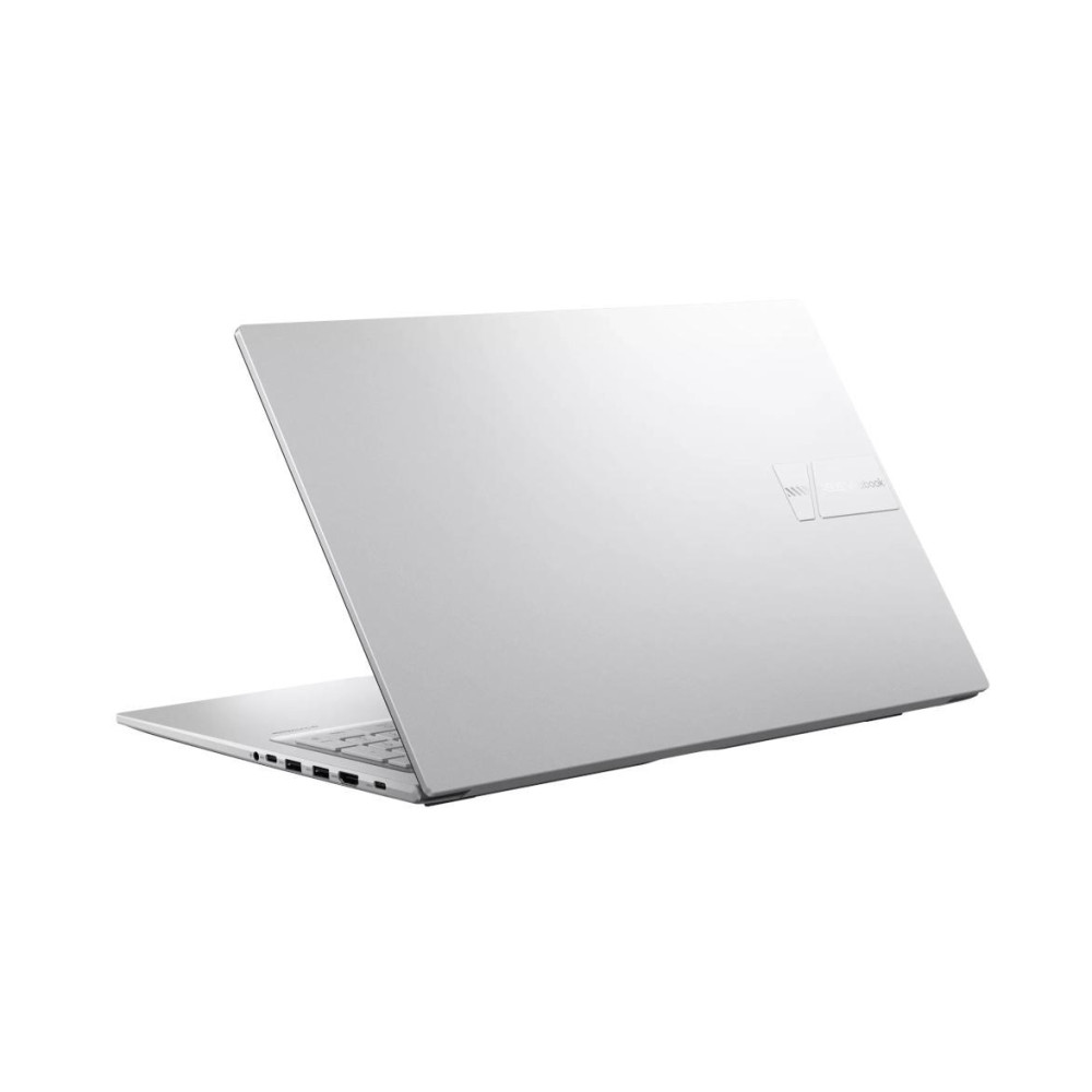 Srebrny laptop stoi na białej powierzchni, pokazując swoje porty.