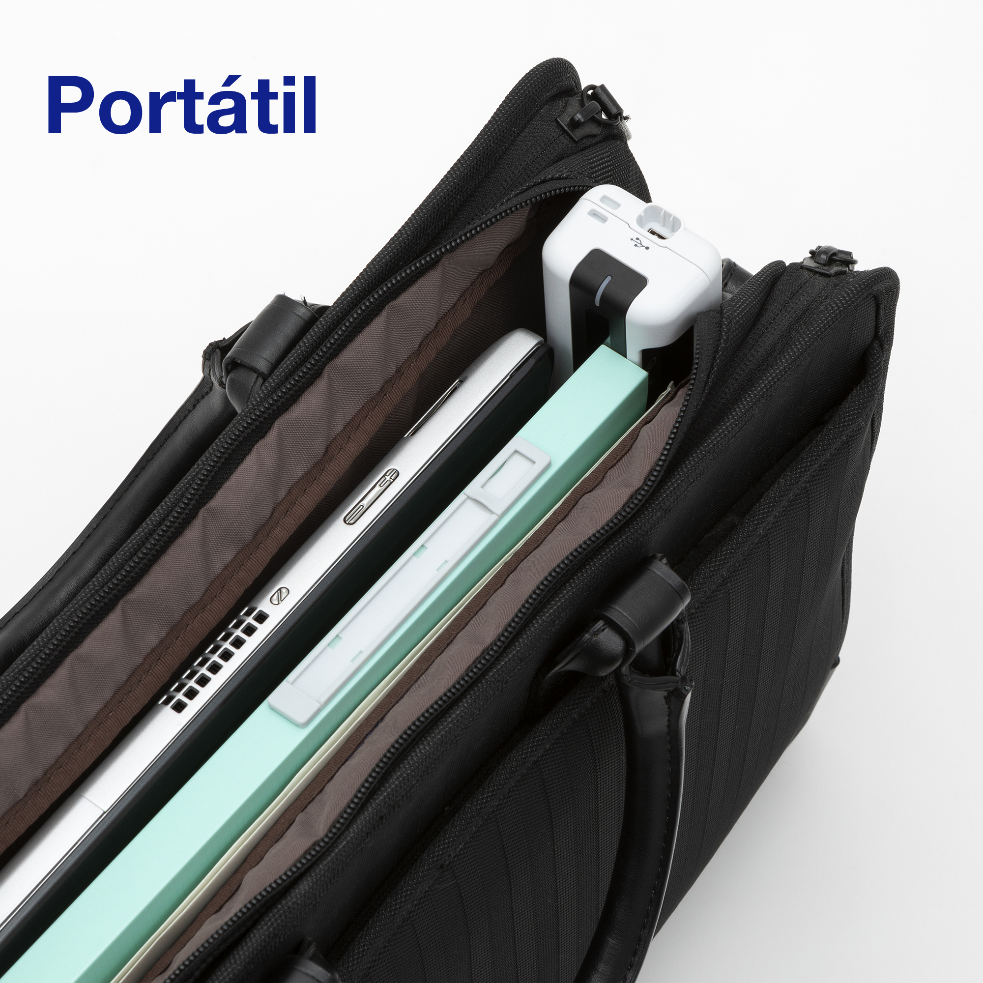 Un sac noir ouvert contenant un ordinateur portable, un carnet vert clair et une batterie externe blanche.