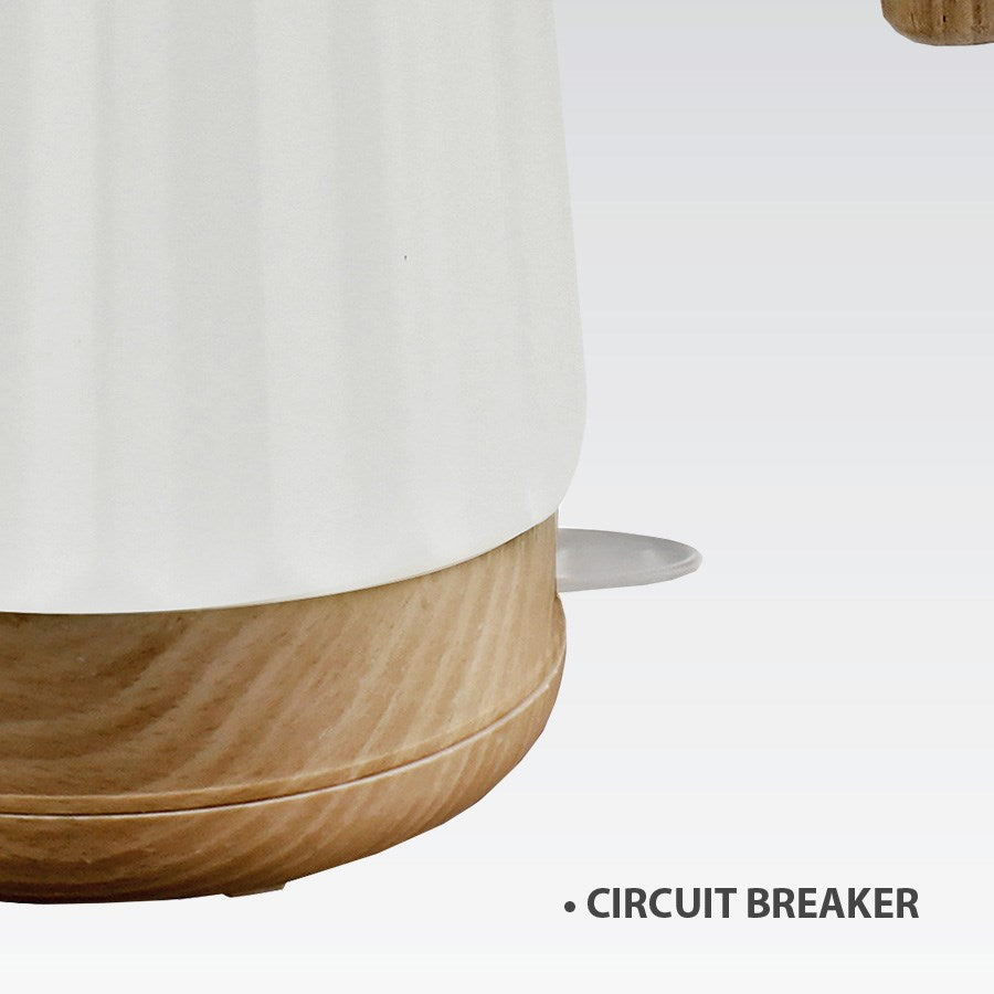 Zbliżenie białego czajnika z drewnianą podstawą i napisem 'CIRCUIT BREAKER'.
