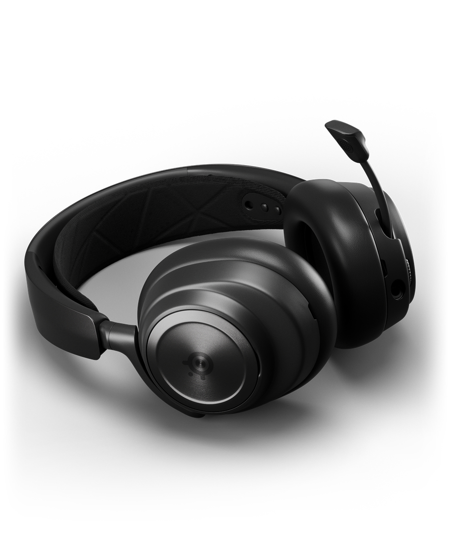 Auriculares negros para juegos con diadema, orejeras y micrófono extendido sobre fondo blanco.