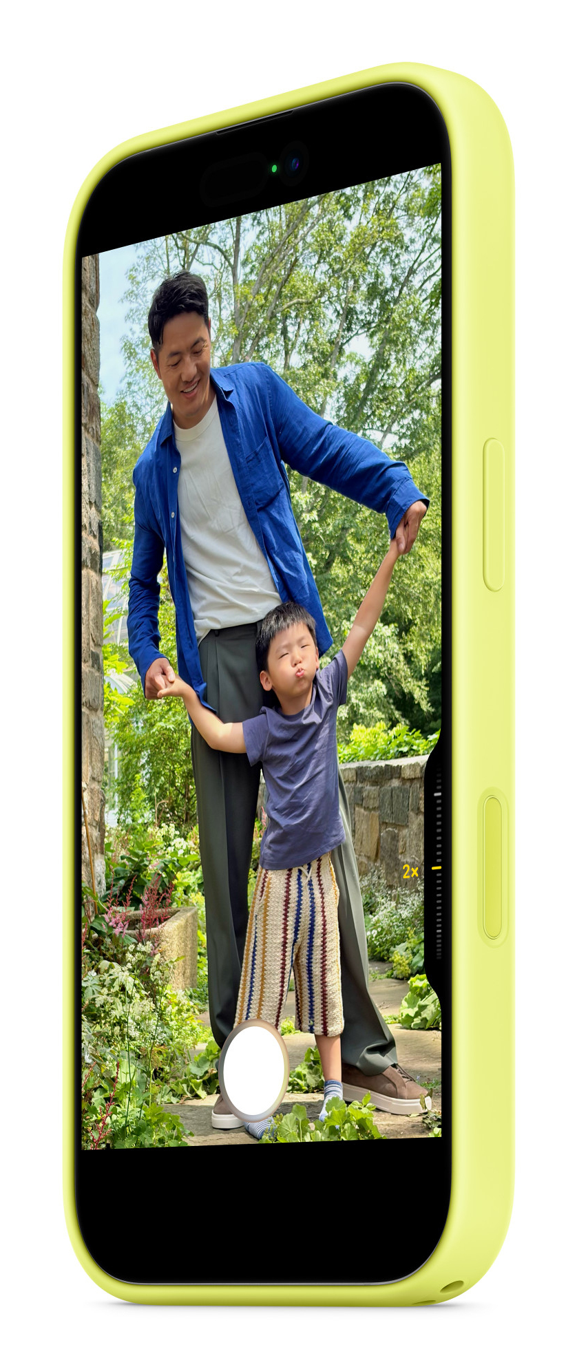 Ein gelbes Smartphone zeigt auf dem Bildschirm einen Vater und Sohn im Garten.