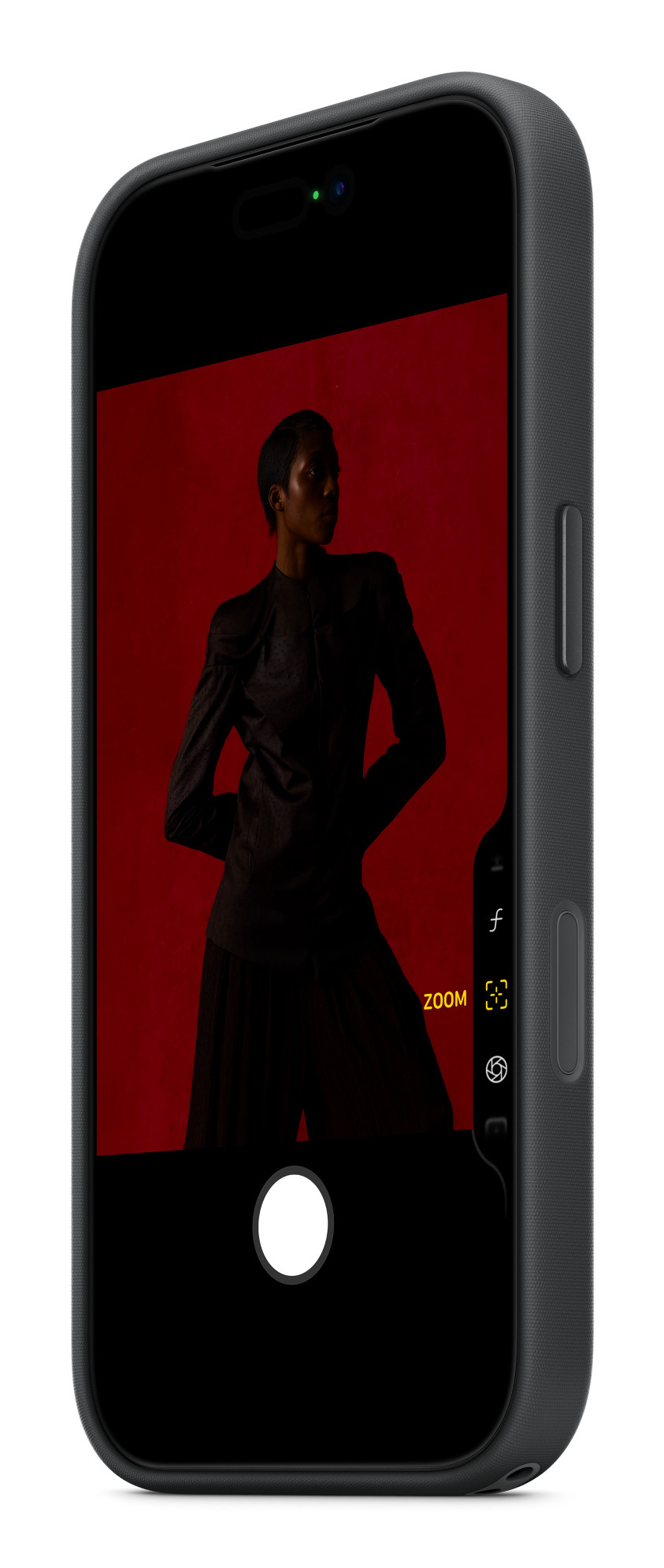 Uno smartphone in custodia scura mostra l'interfaccia di una fotocamera con una persona su sfondo rosso.