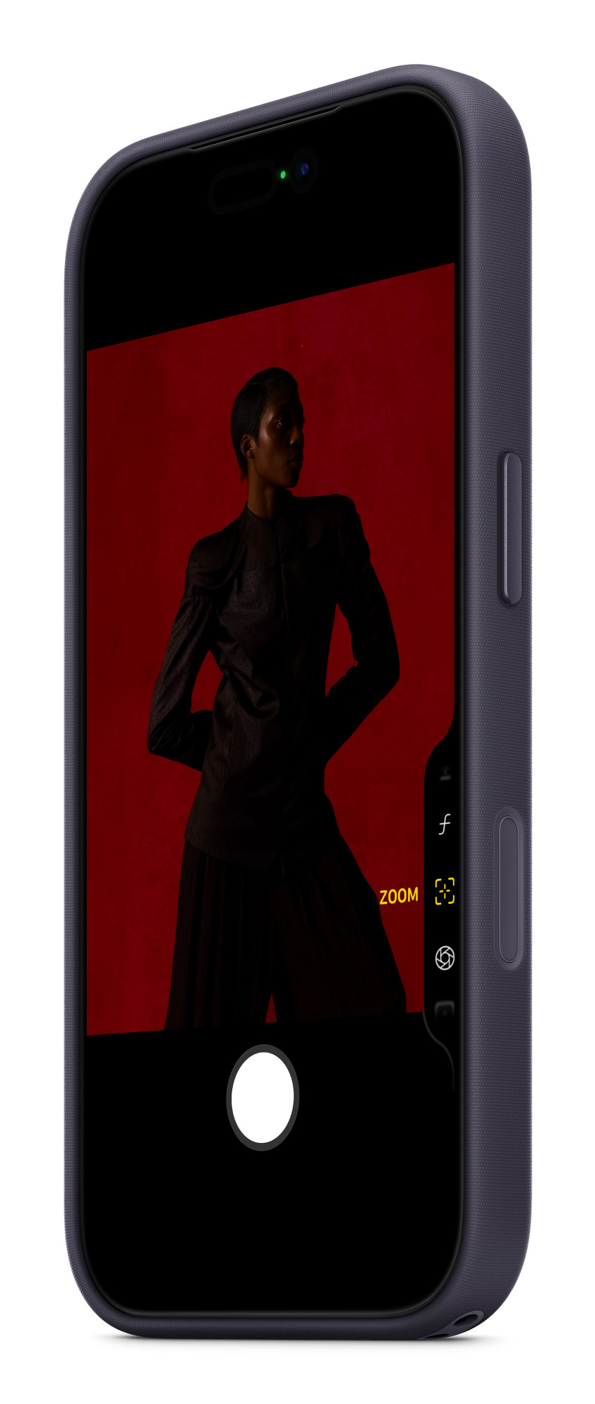 Uno smartphone mostra sullo schermo la foto di una persona in abiti scuri su sfondo rosso.