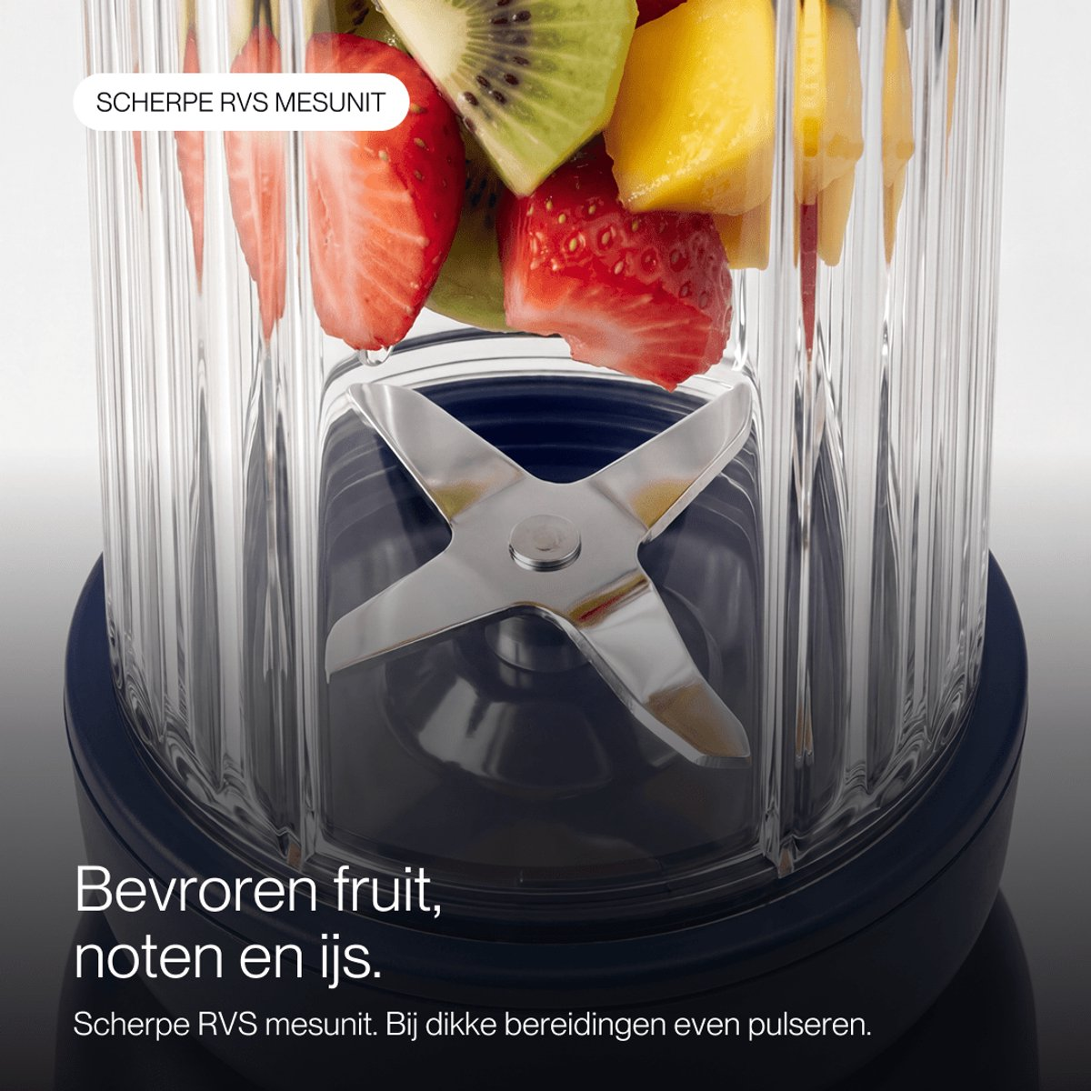 Fruits frais dans un mixeur avec des lames en acier inoxydable.