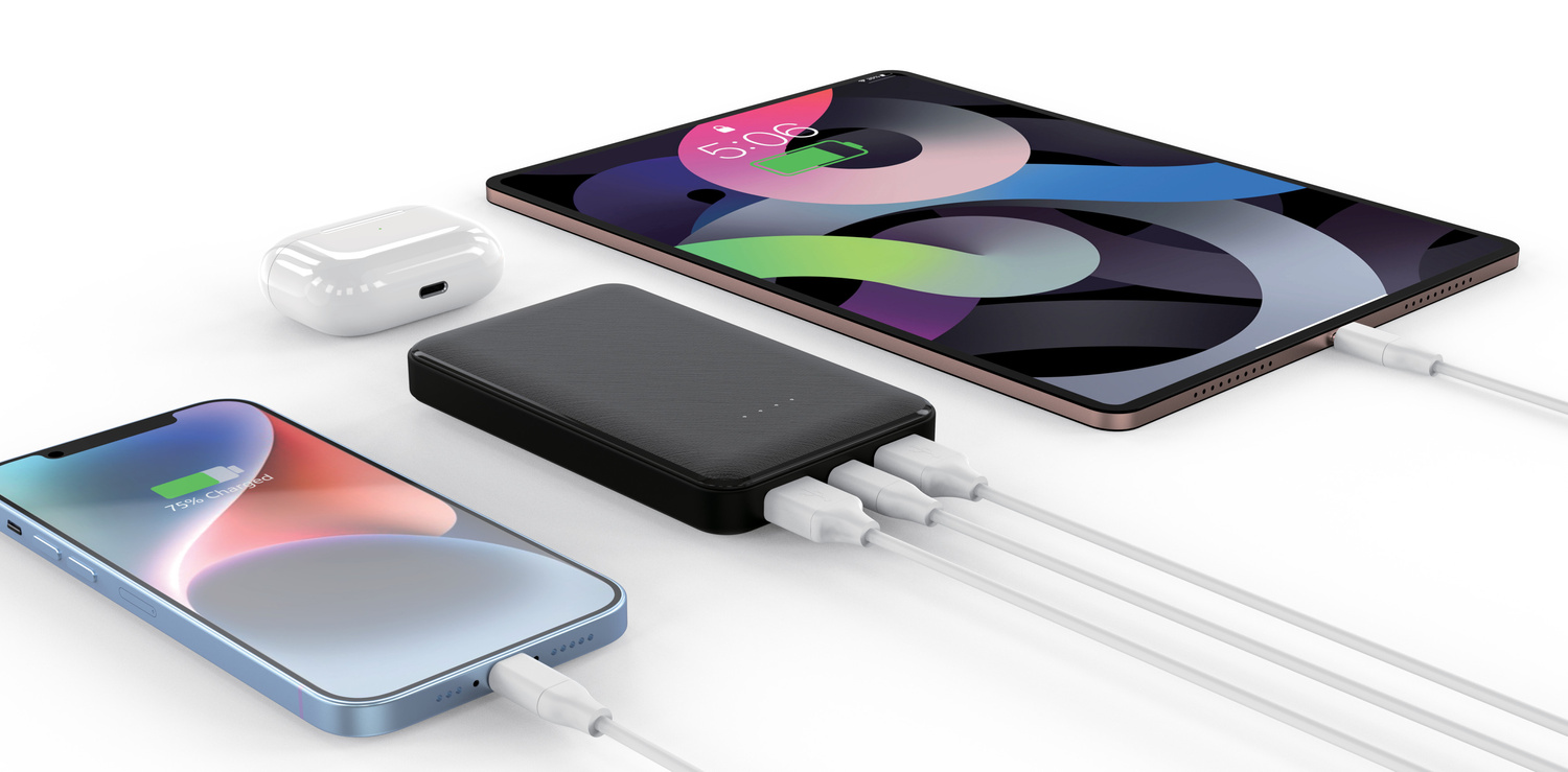 Czarny powerbank ładuje niebieski telefon, tablet i słuchawki bezprzewodowe za pomocą białych kabli.