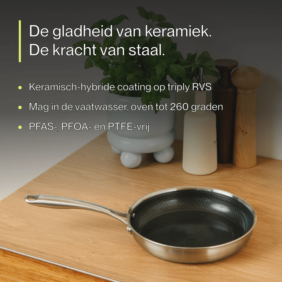 A stainless steel frying pan on a wooden counter with Dutch promotional text.