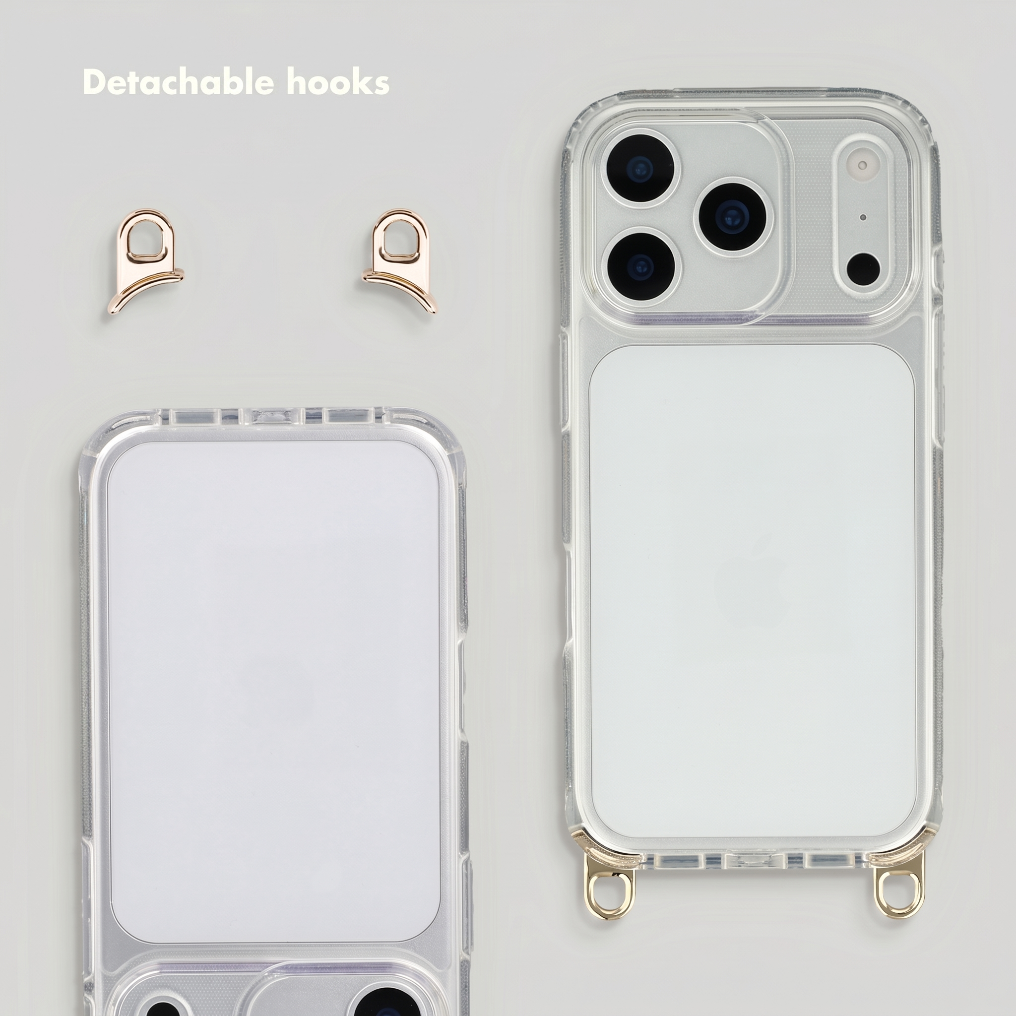 Transparente Handyhülle mit zwei abnehmbaren goldenen Haken auf grauem Hintergrund.