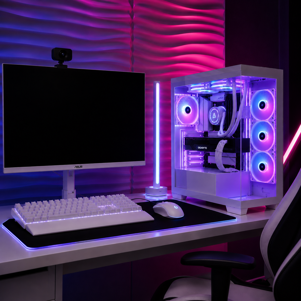 Ein weißes Gaming-Setup mit PC, Tastatur und Monitor vor einer rosafarbenen und blauen Wand.