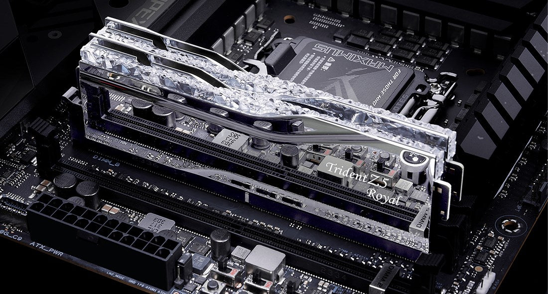Zbliżenie pamięci RAM Trident Z5 Royal z krystalicznymi radiatorami na płycie głównej.