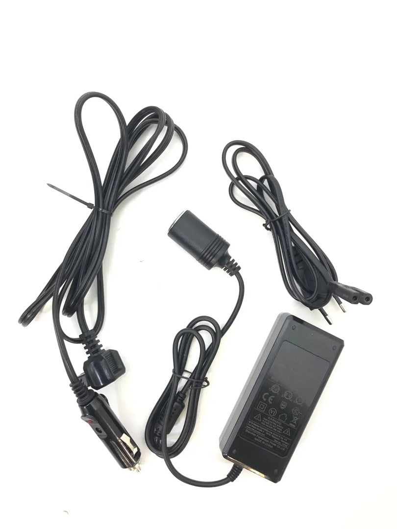 Ein schwarzes Netzteil mit gewickelten Kabeln, Zigarettenanzünder-Adapter und Steckern auf weißem Hintergrund.