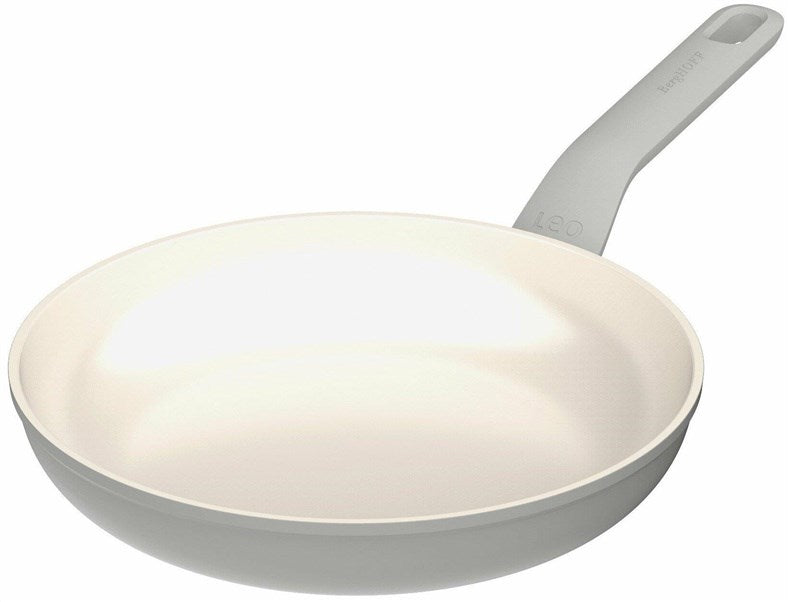 A cream-colored frying pan with a gray handle sits against a white background.