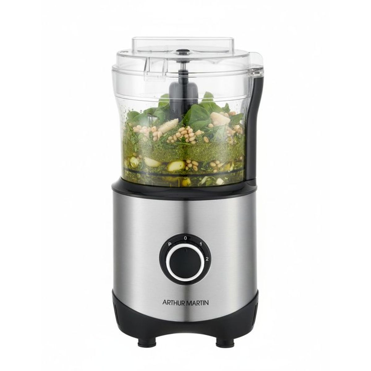 Un robot da cucina argentato con basilico verde, aglio e pinoli nella ciotola trasparente su sfondo bianco.
