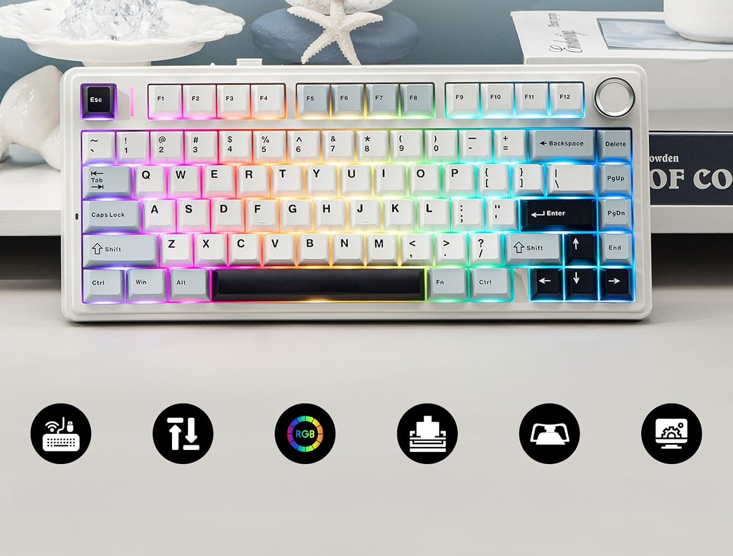 Biała klawiatura mechaniczna z podświetleniem RGB na stole z ikonami poniżej.