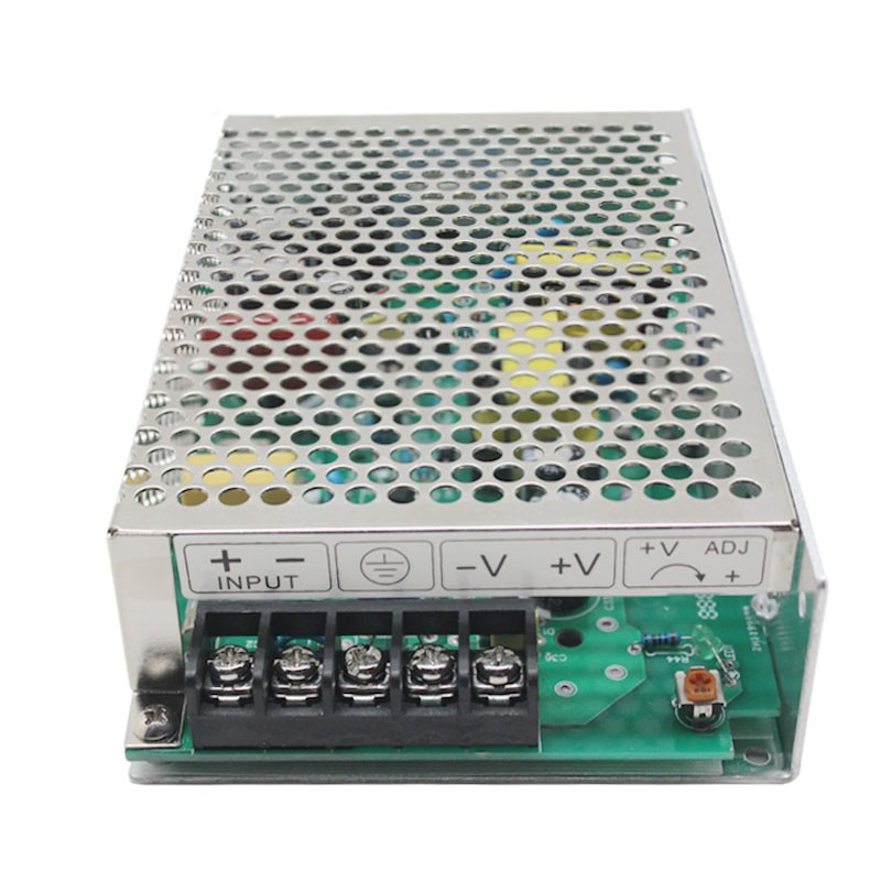 Un alimentatore switching AC-DC argento con coperchio metallico forato e circuito verde.