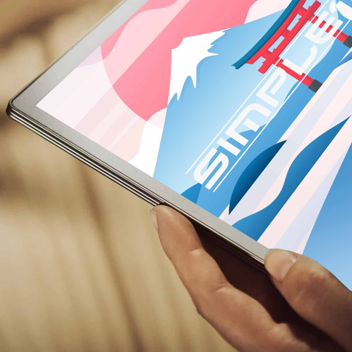 Una mano tiene un tablet che mostra la grafica del Monte Fuji e un torii rosso.