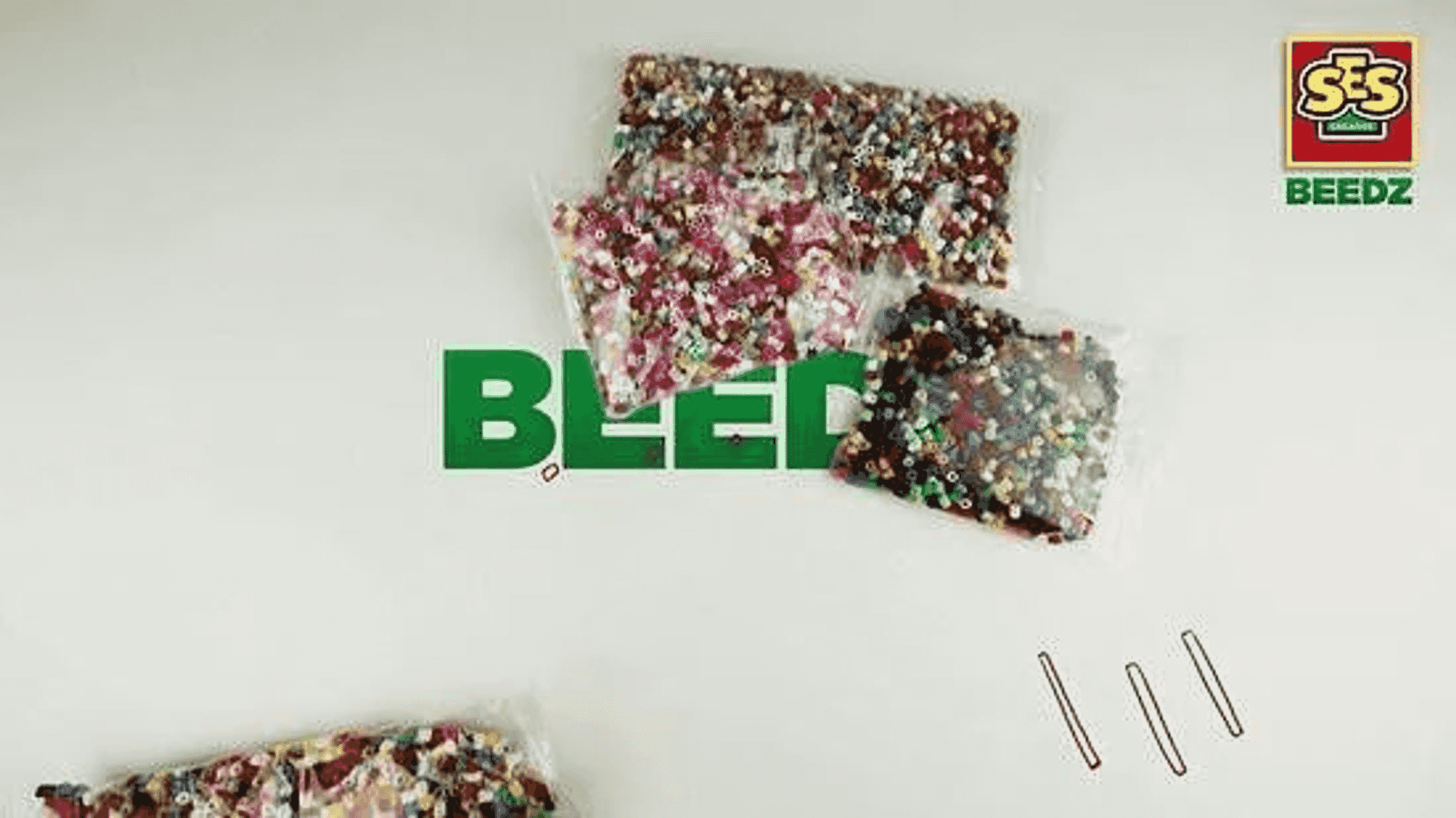 Bolsas de plástico con cuentas de colores sobre una superficie clara, con letras verdes y el logotipo de SES Beedz.