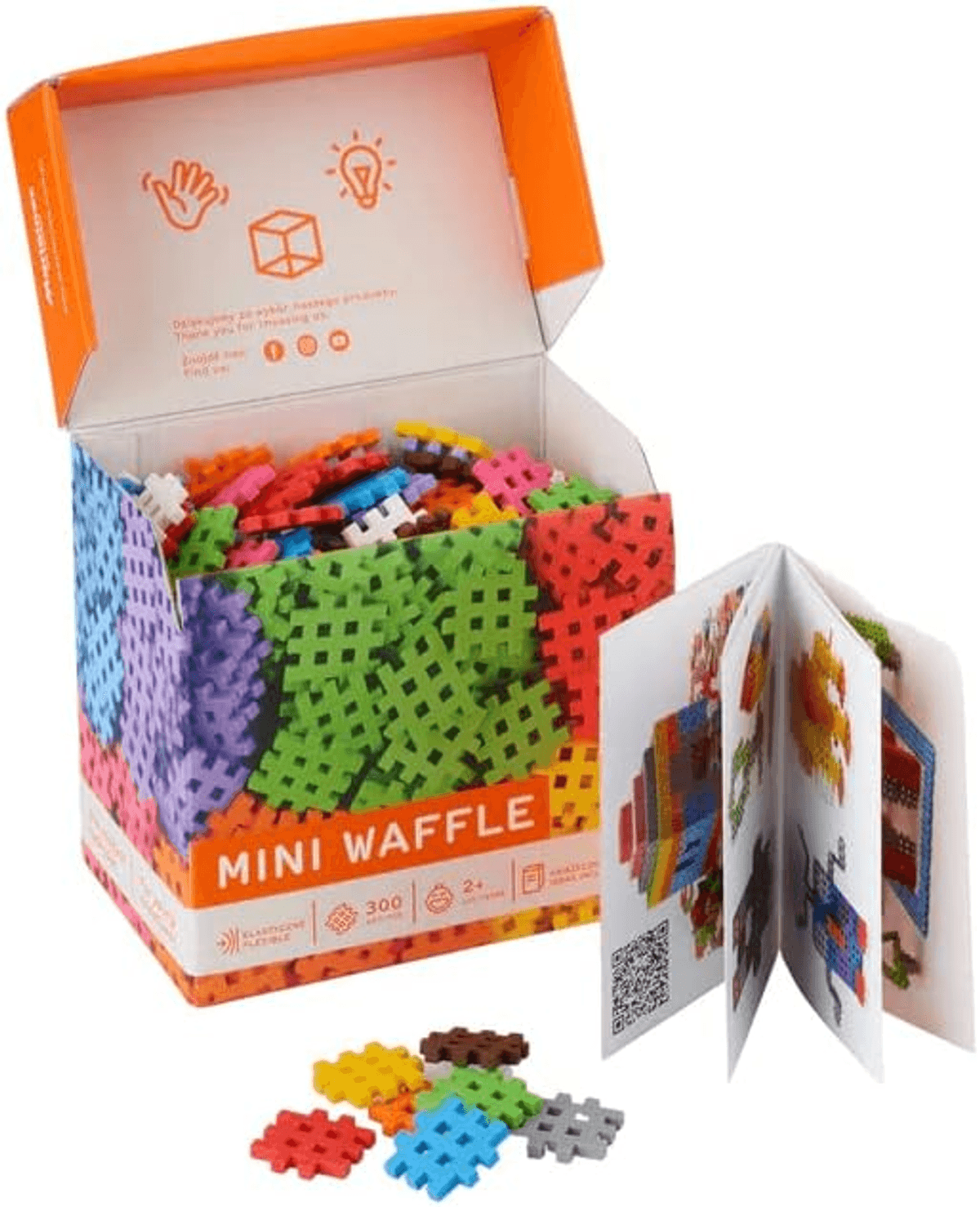 Una caja abierta de Mini Waffle con bloques coloridos, un folleto de instrucciones y piezas sueltas enfrente.