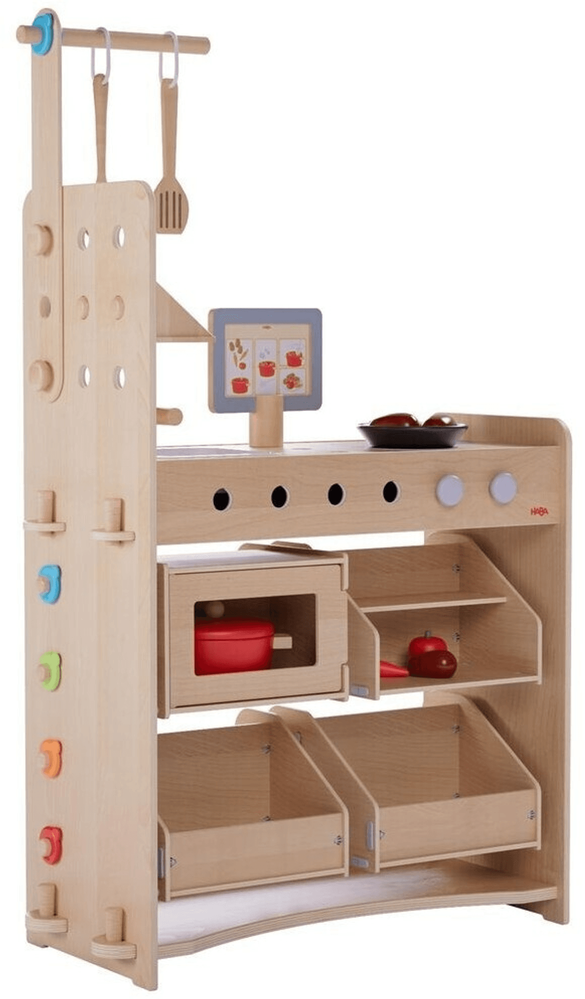 Eine hölzerne Spielküche mit Utensilien, Mikrowelle und Regalen voller Spielzeuglebensmittel auf weißem Grund.