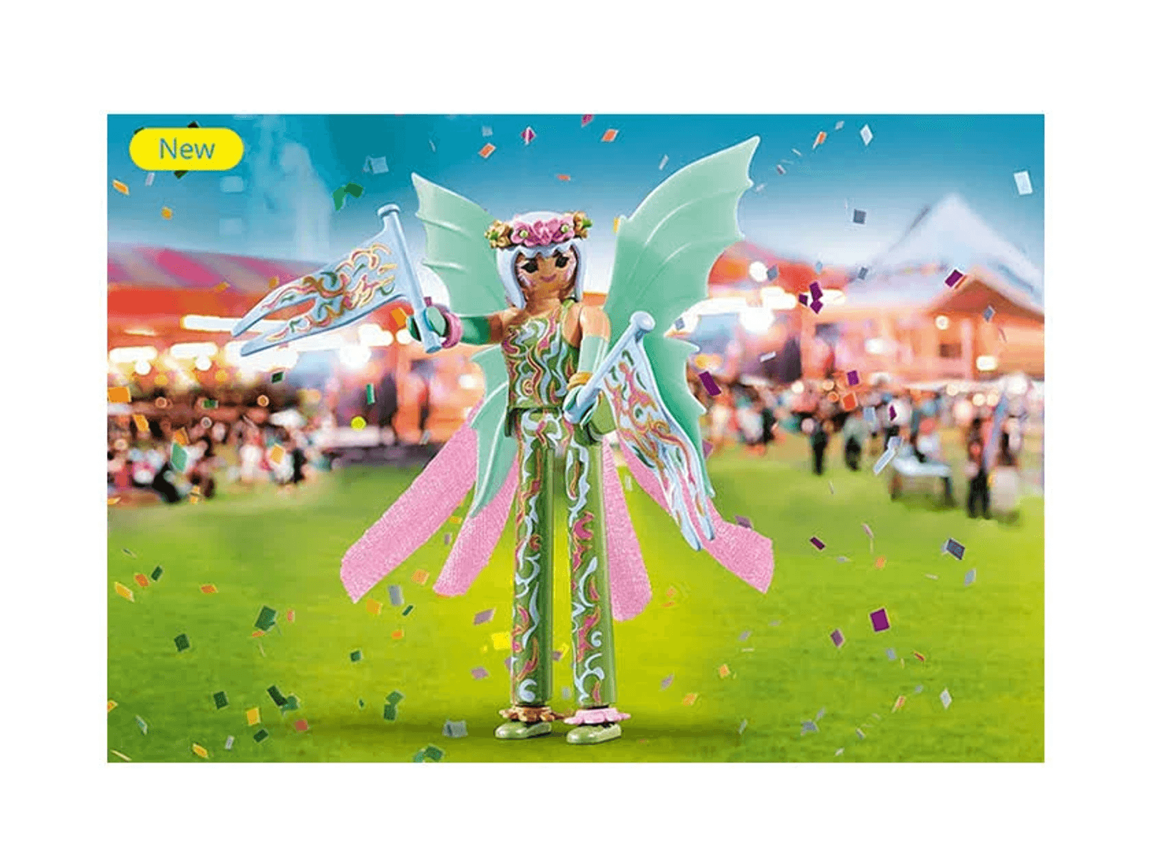 Un hada de Playmobil con ropa verde estampada, alas y dos banderas, de pie en un campo con confeti.