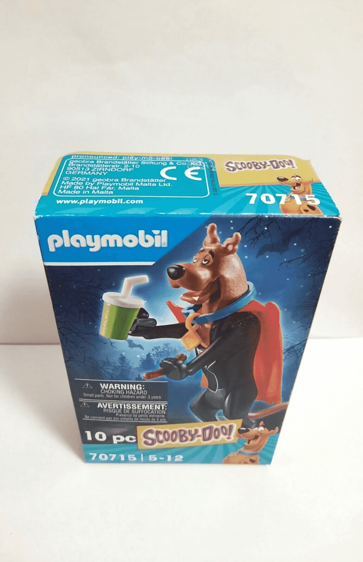 La caja de Playmobil Scooby-Doo muestra a Scooby con bebida y capa sobre fondo nocturno.