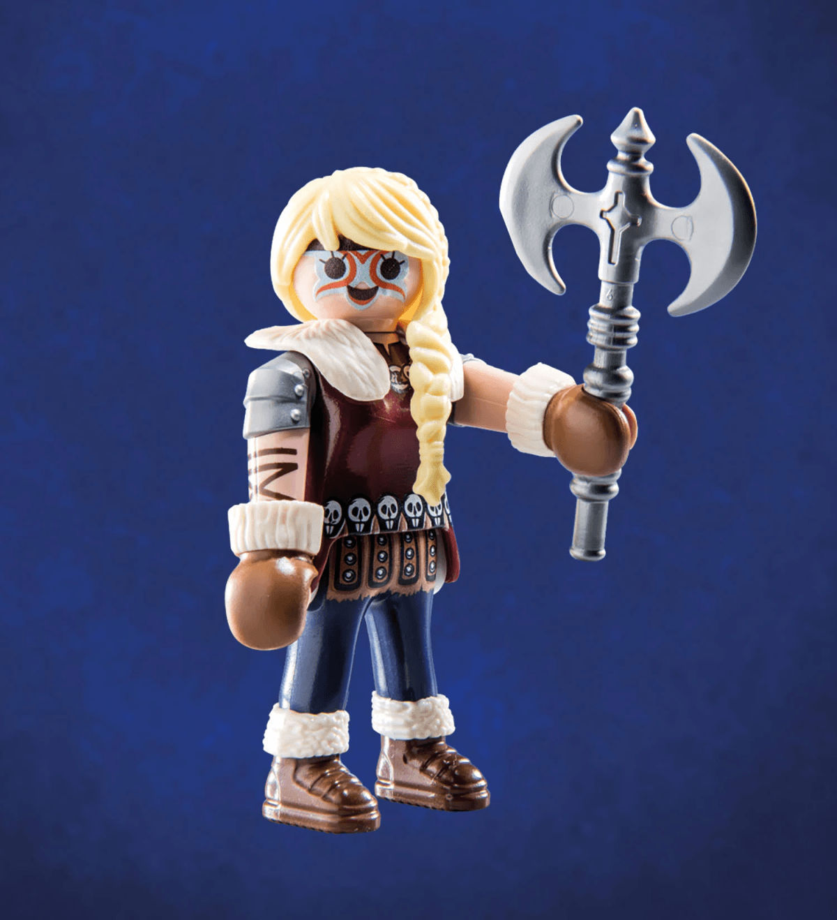 Figura de vikingo Playmobil con trenza rubia, pintura facial, abrigo de piel y un gran hacha de doble hoja sobre fondo azul.