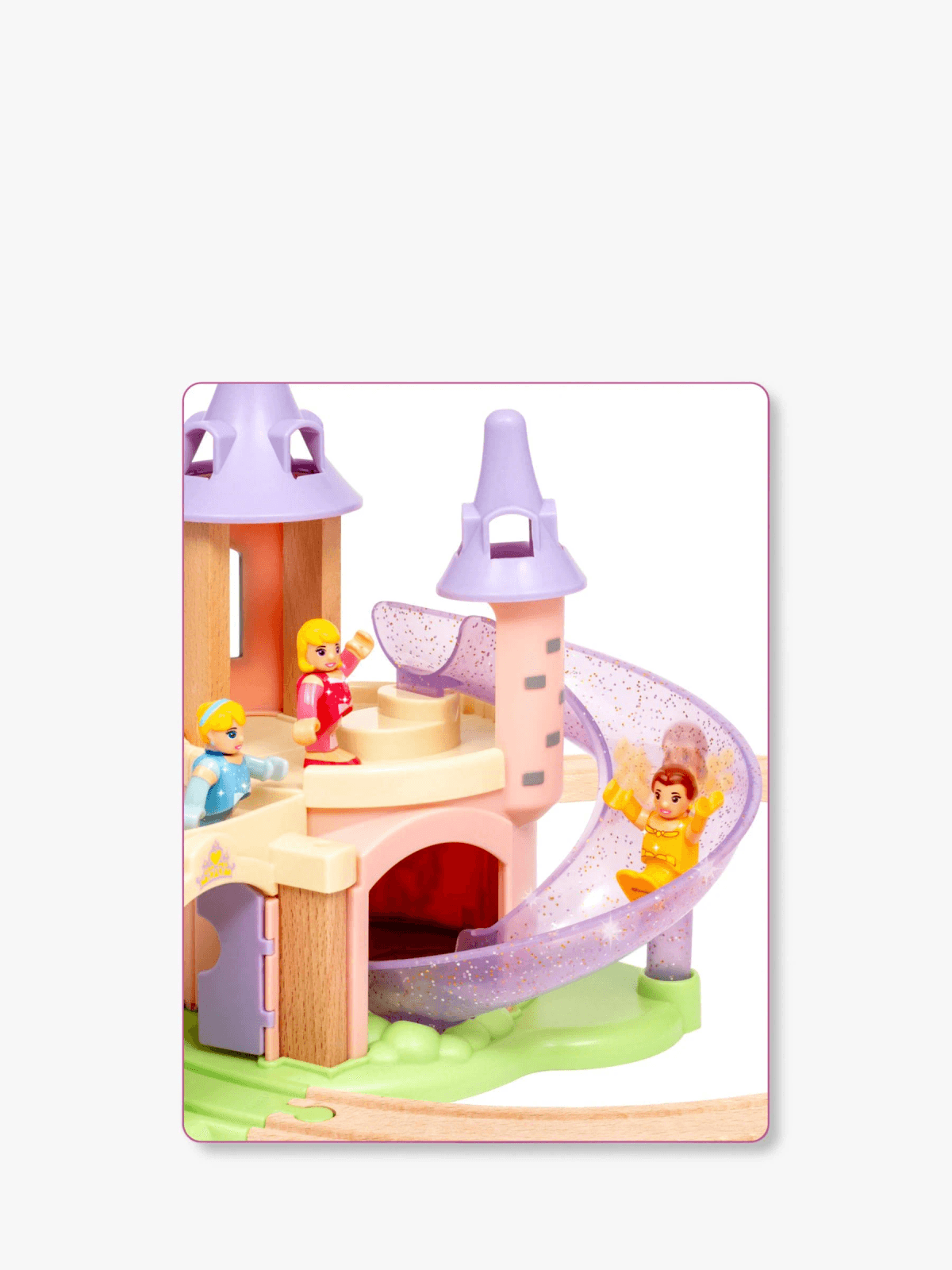 Un castillo de juguete rosa con torres, un tobogán y tres figuras pequeñas.