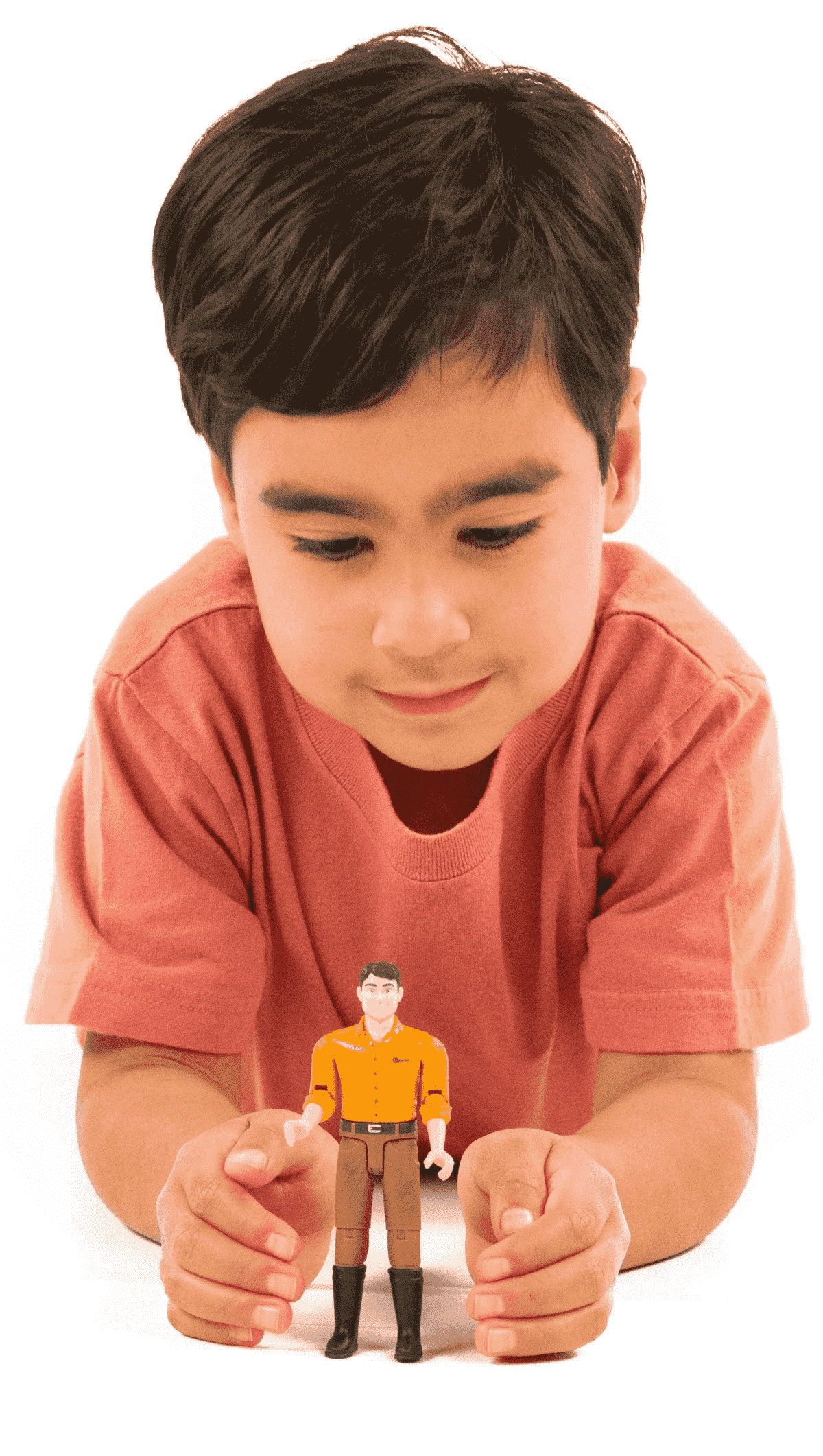 Un bambino con una camicia arancione guarda in basso, sorridendo a un piccolo action figure.
