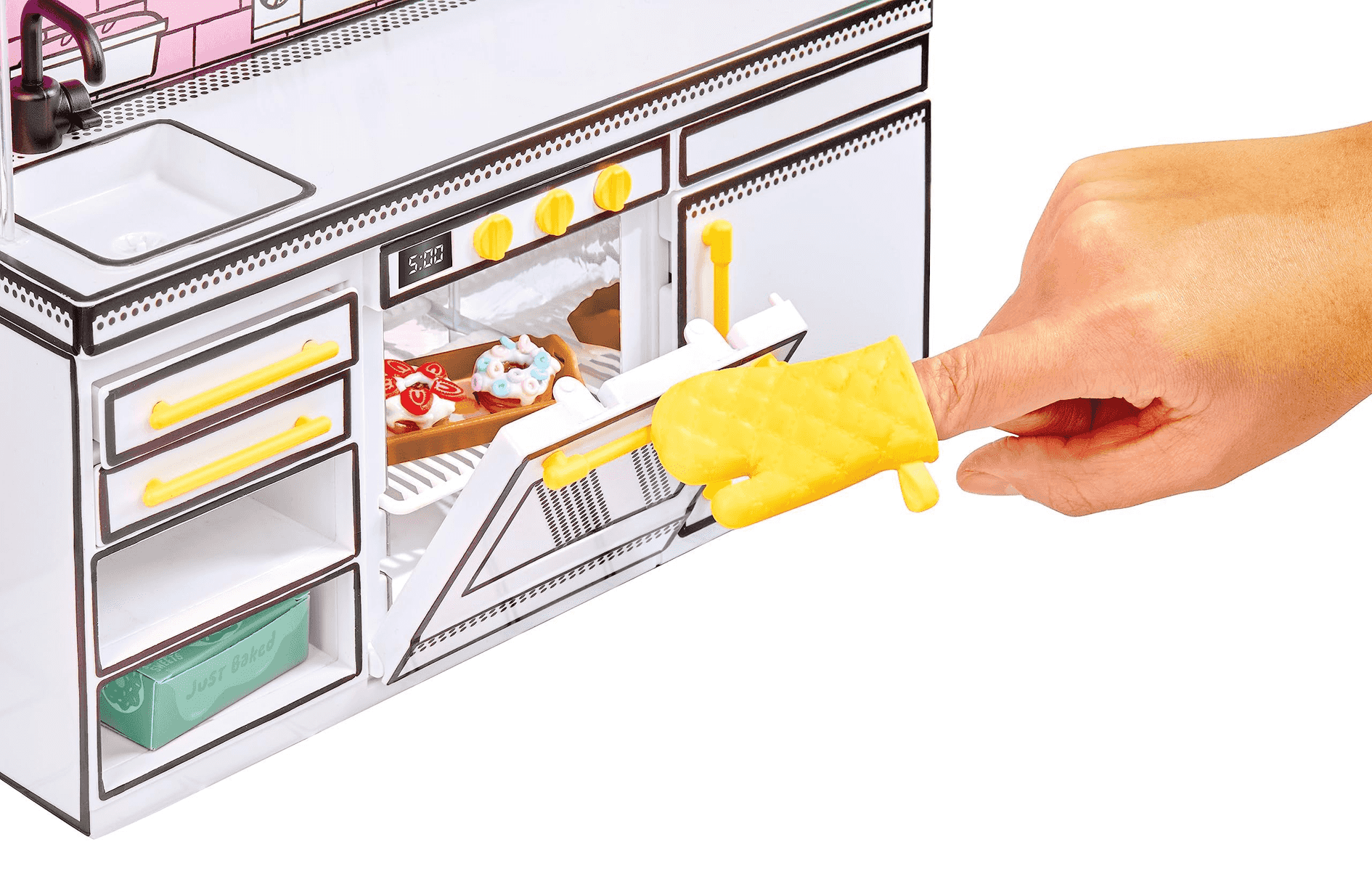 Una mano con un guante de cocina amarillo abre un horno de juguete con pasteles en miniatura.