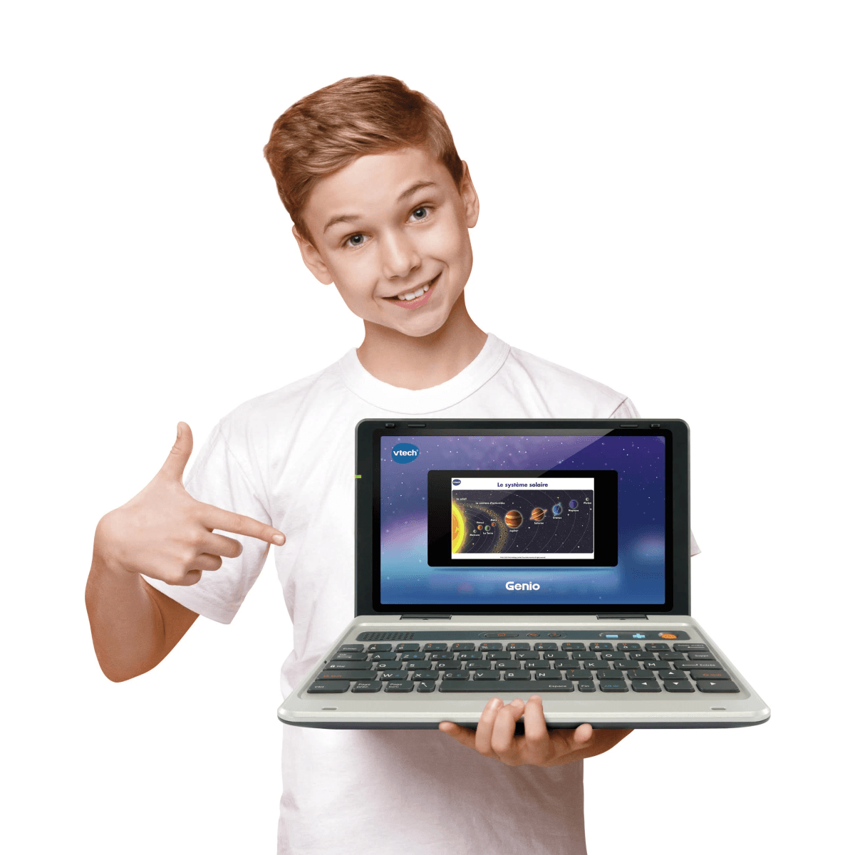 Un niño sonriente con camisa blanca sostiene una laptop educativa VTech Genio, señalando la pantalla con el sistema solar.