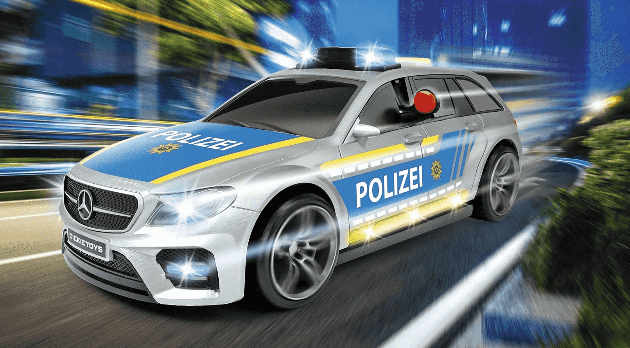 Ein silbernes Polizeiauto fährt mit blinkenden Lichtern und Bewegungseffekten schnell durch eine Straße.