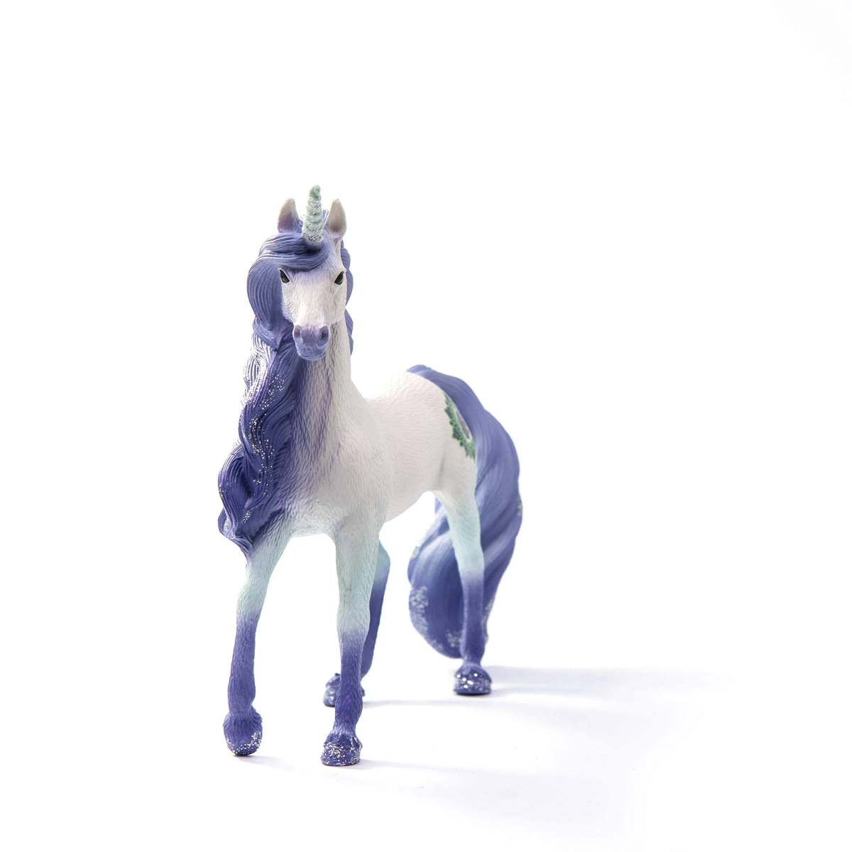 Eine weiße und violette Einhorn-Figur mit glitzernder Mähne und Horn vor weißem Hintergrund.
