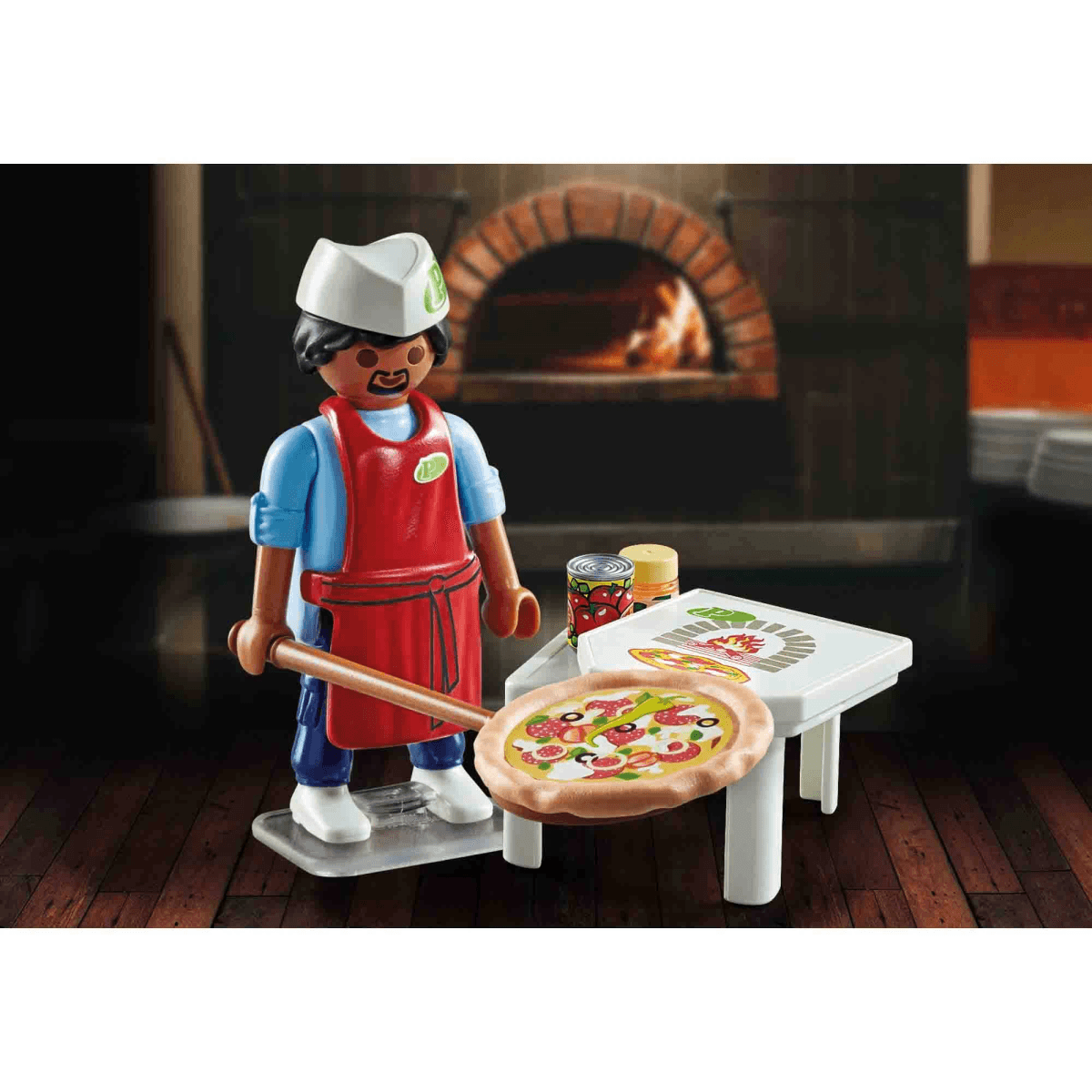 Pizzero de Playmobil con delantal rojo sosteniendo una pala de madera con pizza ante un horno.
