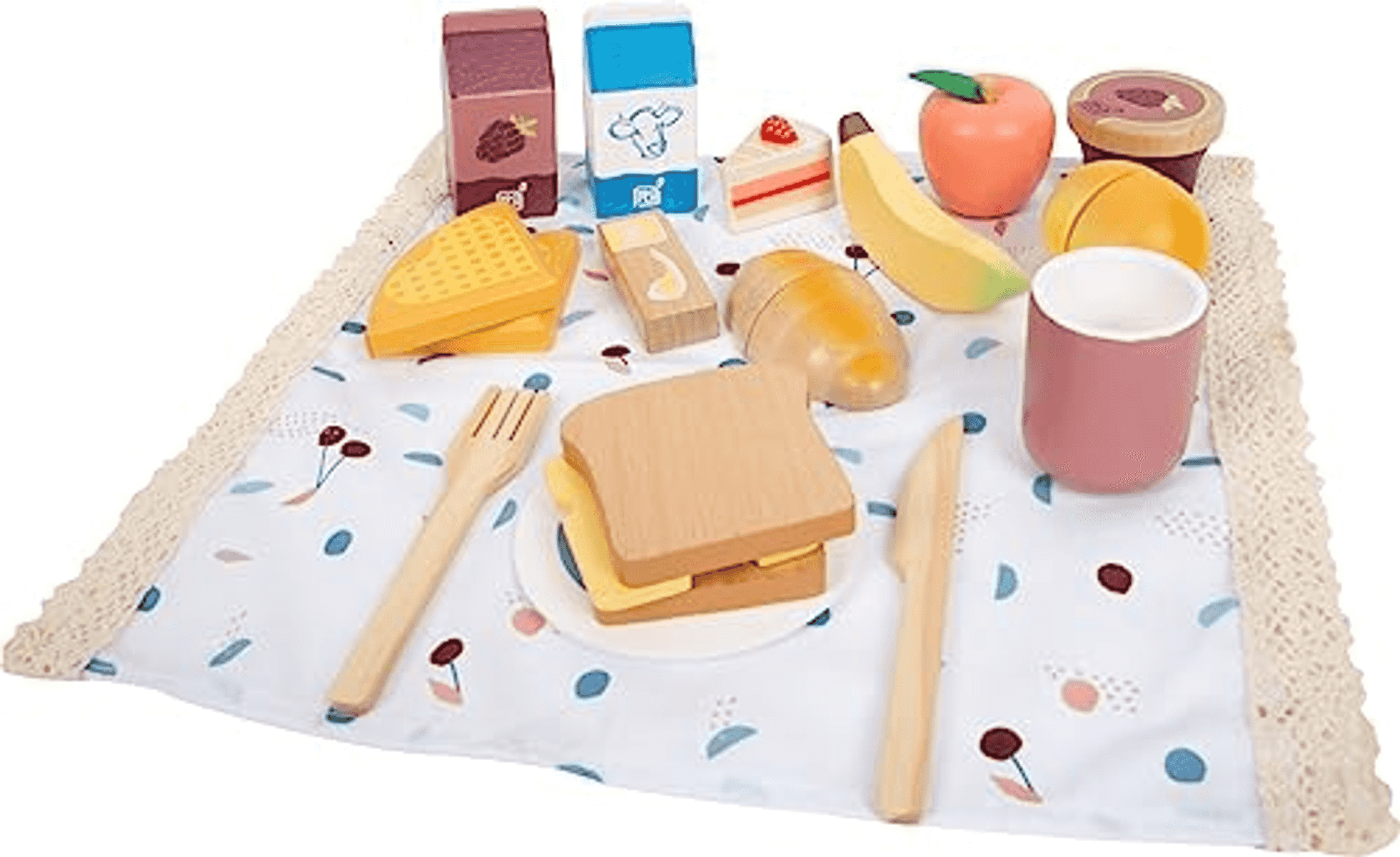 Un juego de alimentos de juguete de madera para picnic, que incluye un sándwich, fruta, cartones de leche y utensilios sobre una manta.