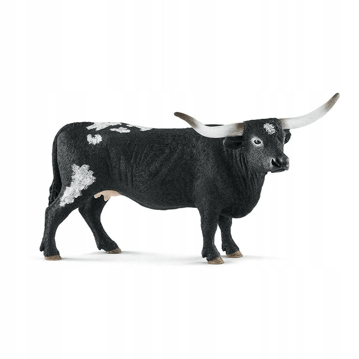 Eine Spielfigur einer schwarz-weißen Texas-Longhorn-Kuh mit langen Hörnern auf weißem Grund.