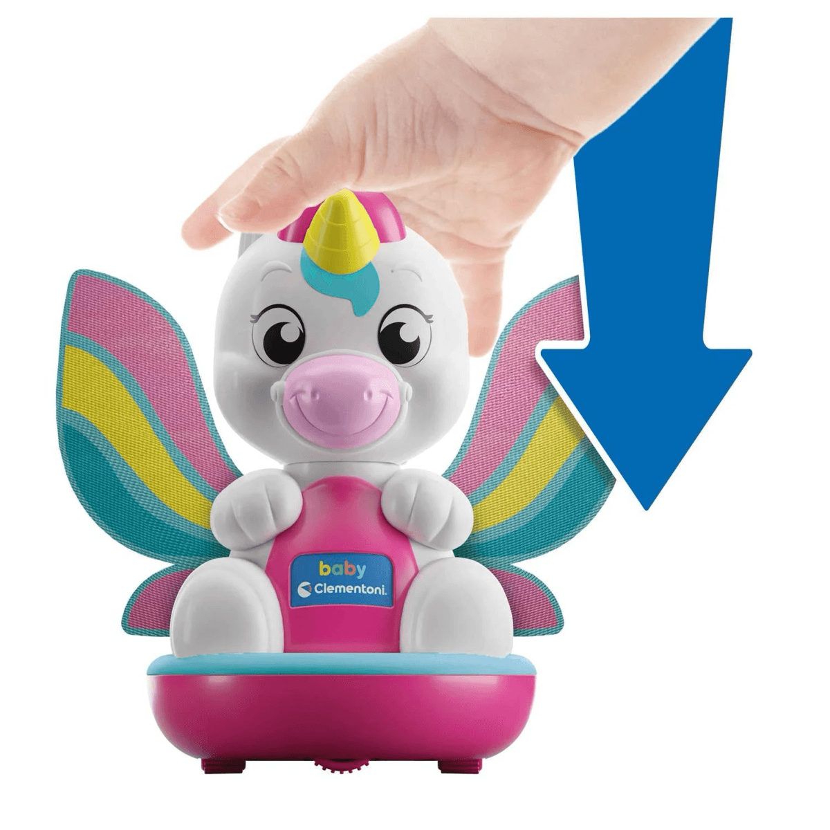 Una mano presiona un lindo unicornio de juguete blanco y rosa con alas de arcoíris.