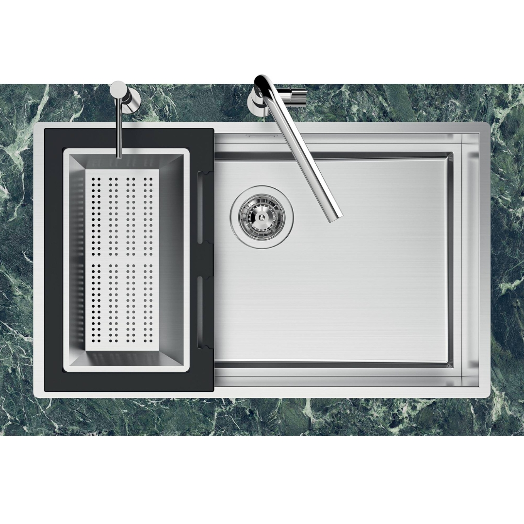 Lavello in acciaio inox con colino nero e rubinetti cromati, su piano in marmo verde.
