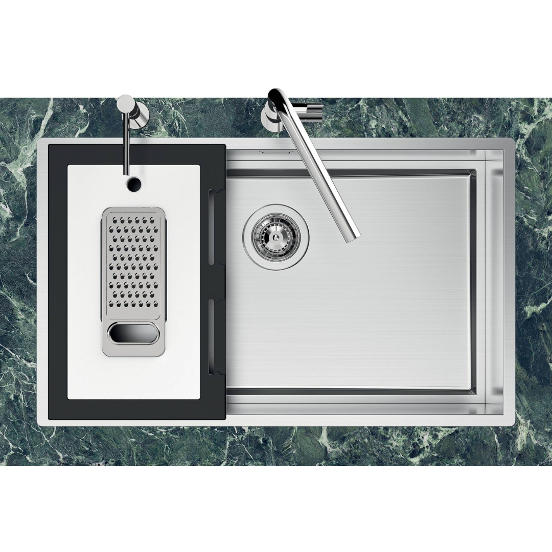 Moderno lavello in acciaio inox con tagliere bianco e rubinetti cromati su marmo verde.