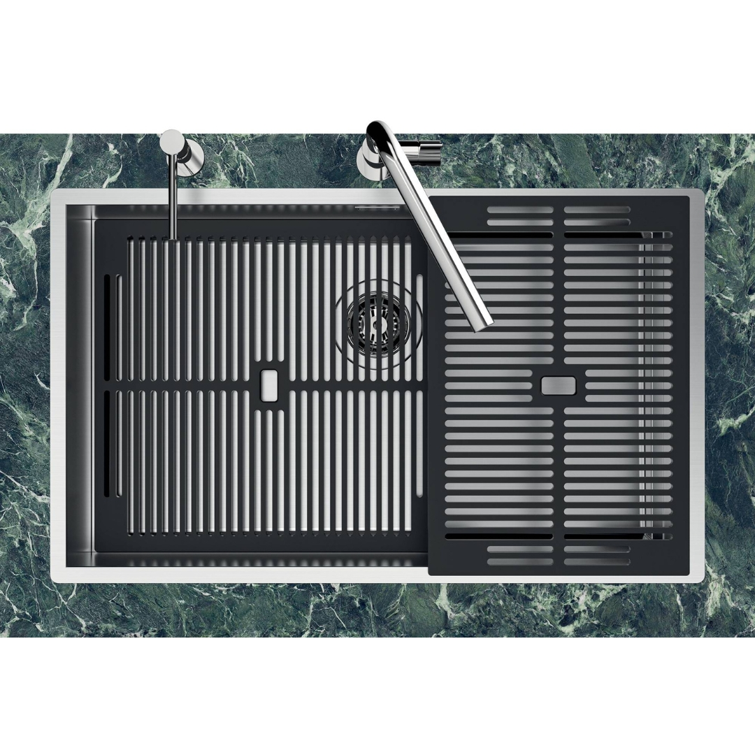 Moderno lavello in acciaio inox con griglia nera su marmo verde.