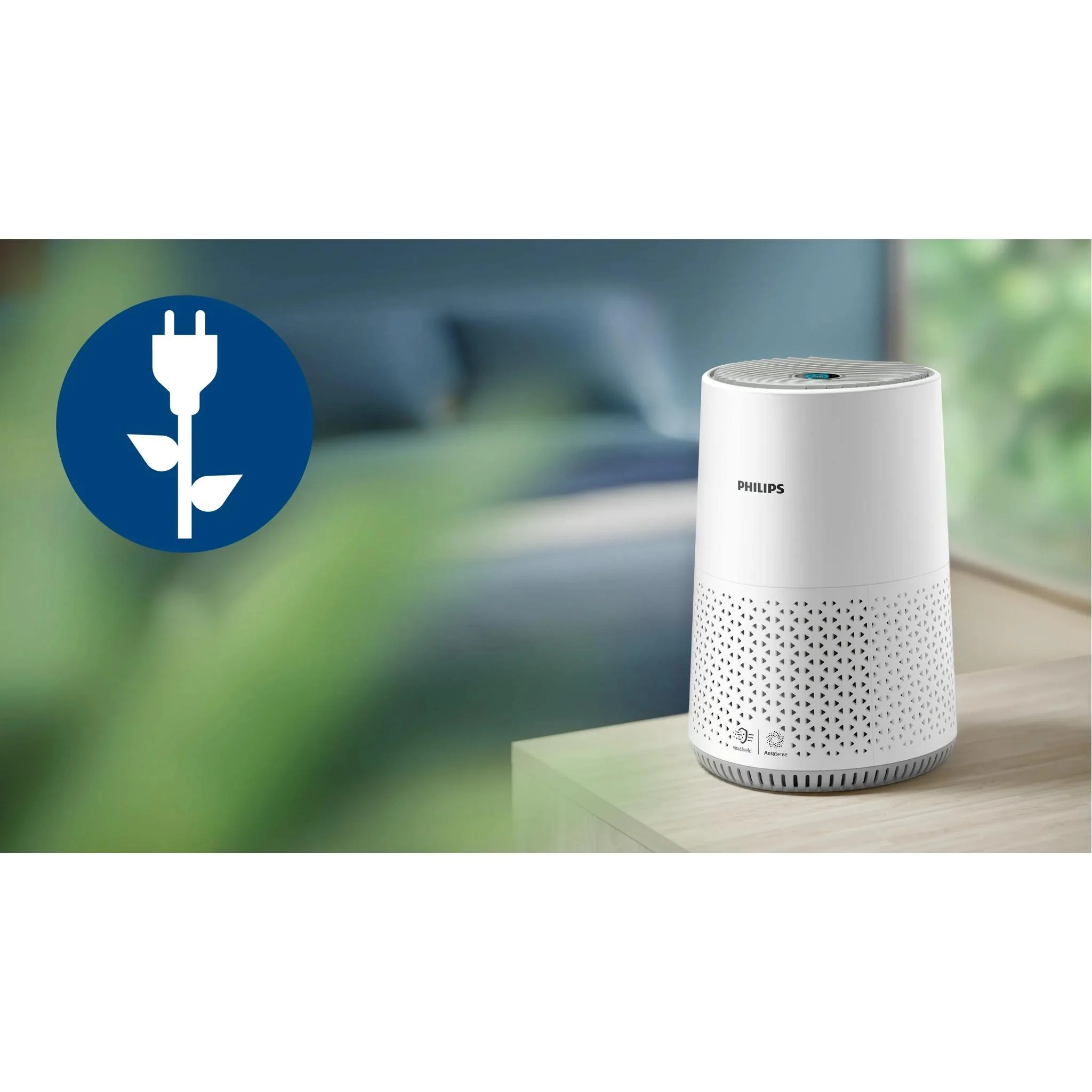 Ahşap masa üzerinde beyaz bir Philips hava temizleyici, solda mavi daire içinde fiş ve yaprak simgesi.