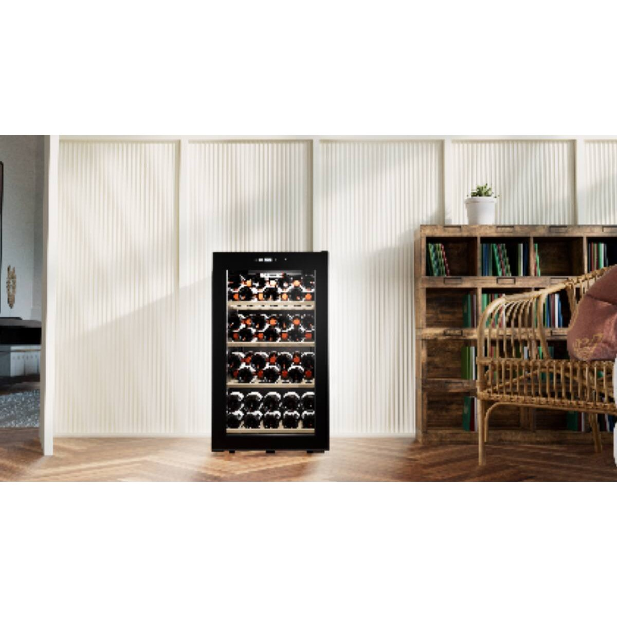 Una vinoteca negra se encuentra en una habitación con suelo de madera, estantería y sillón.