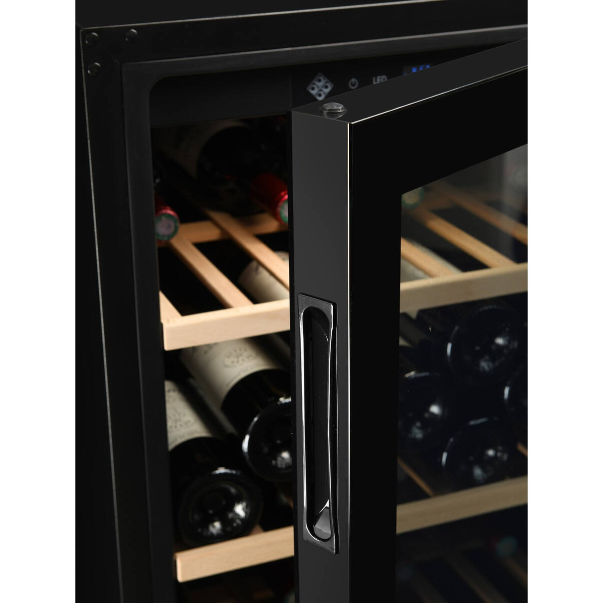 Un enfriador de vinos negro con puerta de vidrio muestra estantes de madera y botellas de vino guardadas.