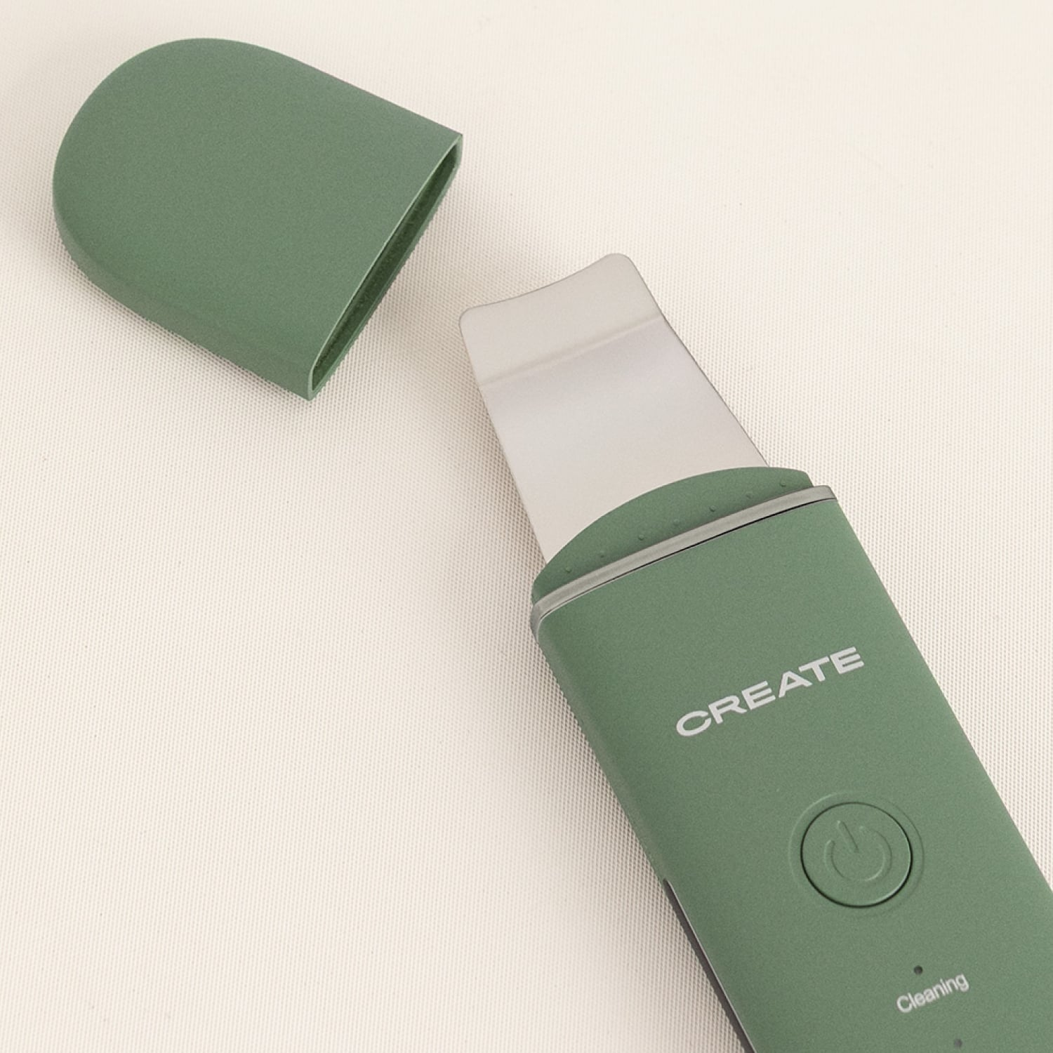 Limpiador facial ultrasónico verde con tapa extraíble sobre fondo blanco.