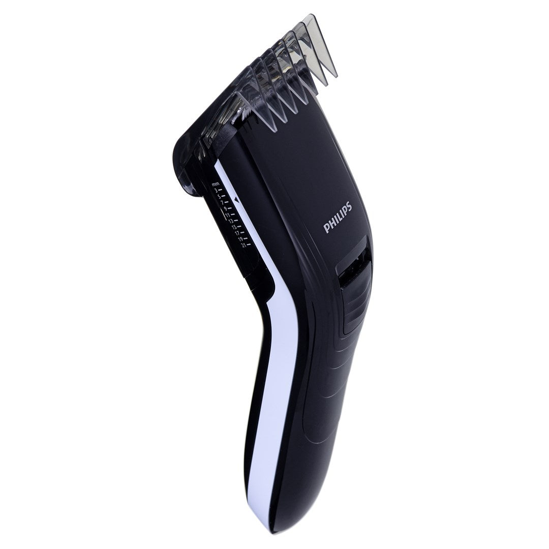 Una recortadora de pelo Philips negra con línea blanca y accesorio de peine transparente sobre fondo blanco.