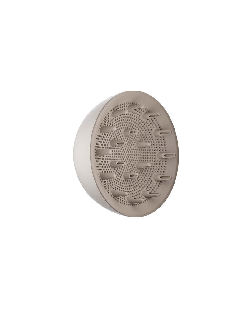 Un diffusore per phon beige con piccoli fori e brevi punte su sfondo bianco.